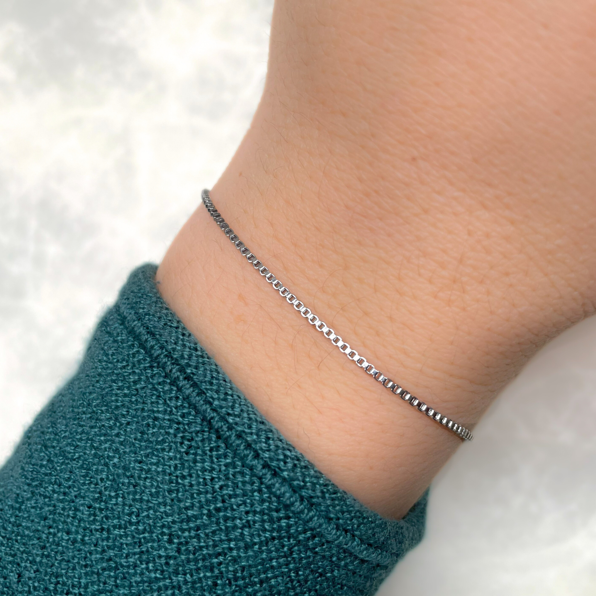 Silver bracelet on a wrist with a blurred background