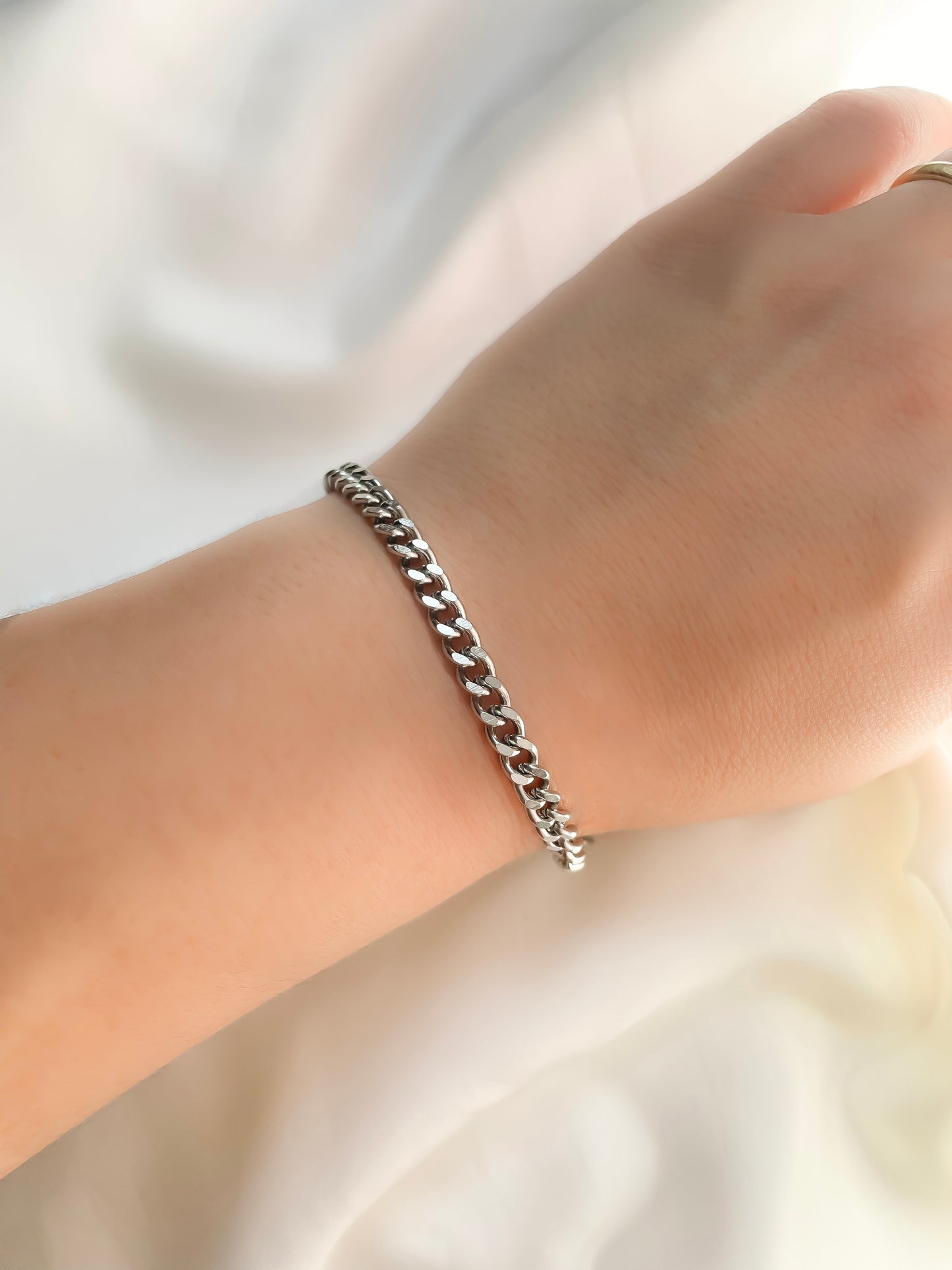 5mm Silver cuban chain bracelet  reflecting light on a wrist against a neutral background
