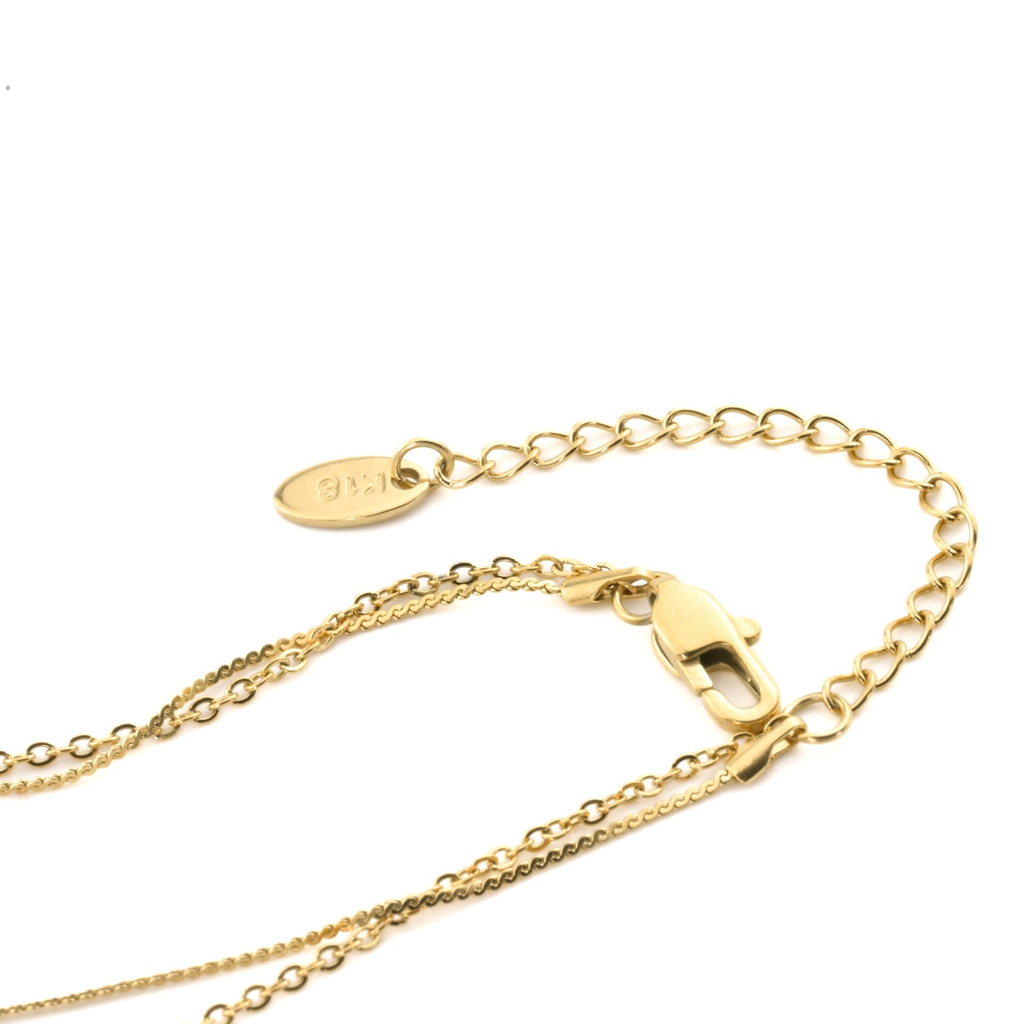 Close-up view of layered gold chain anklet  showcasing the two chains linked with a single clasp