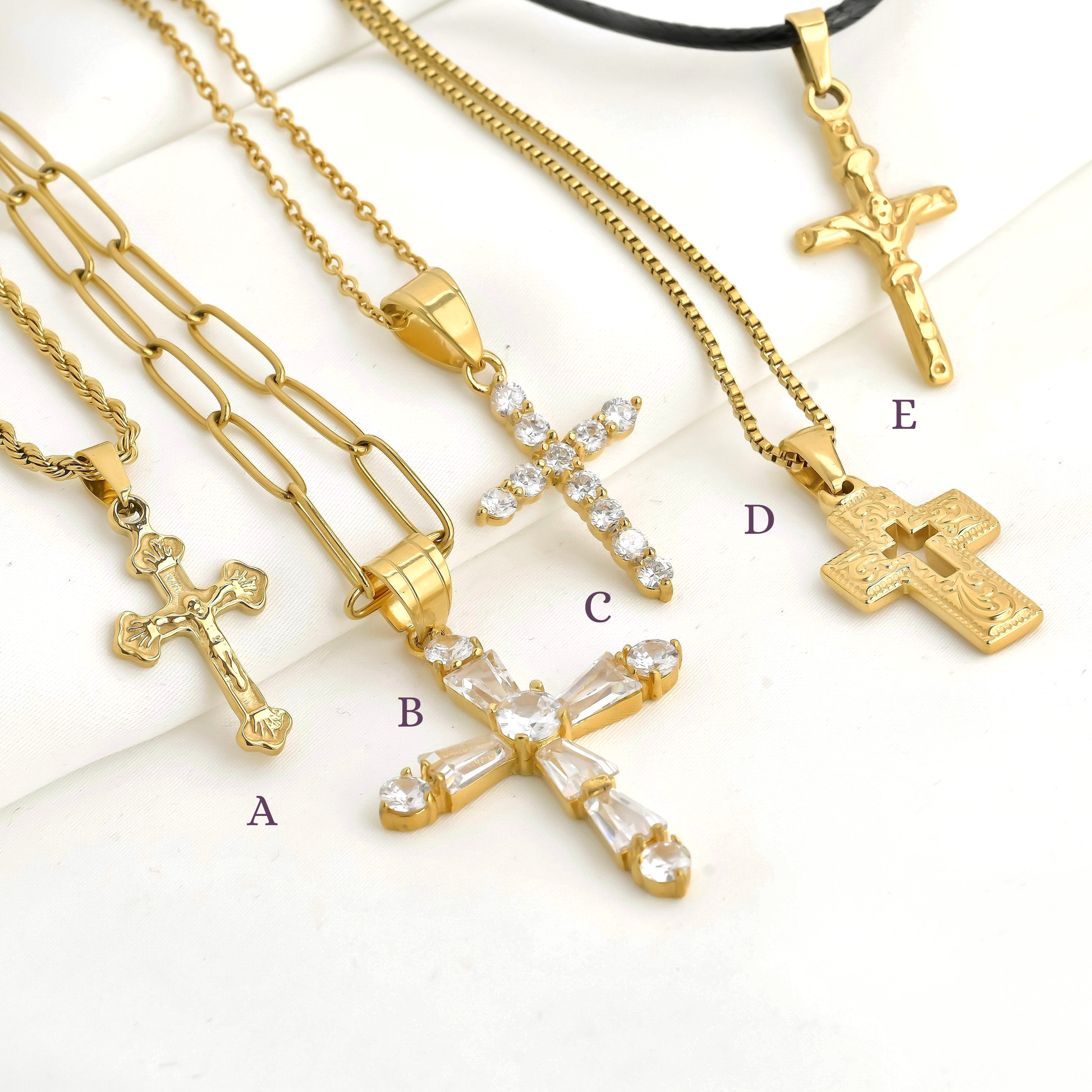 Gold cross necklaces with various designs on a white background with design labels , B, C, D and E