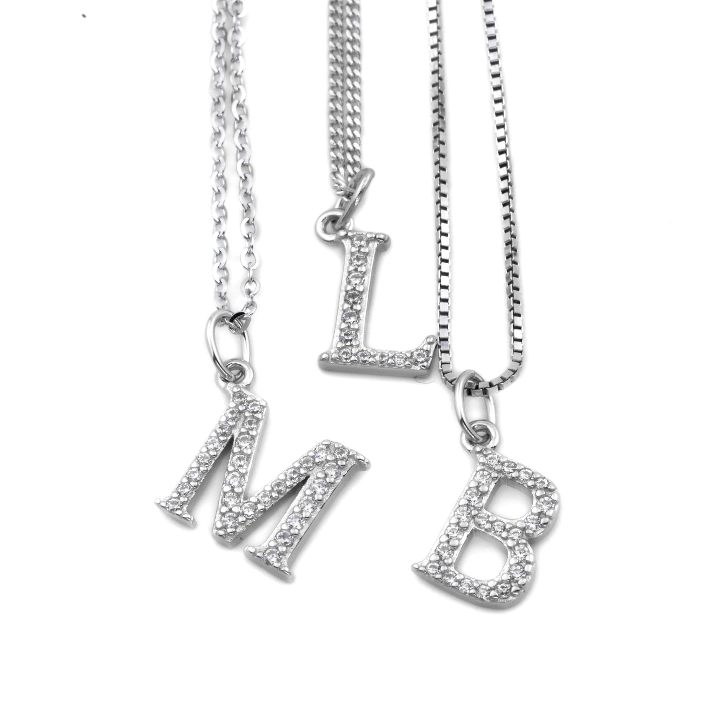 Three silver necklaces with letter pendants on a white background