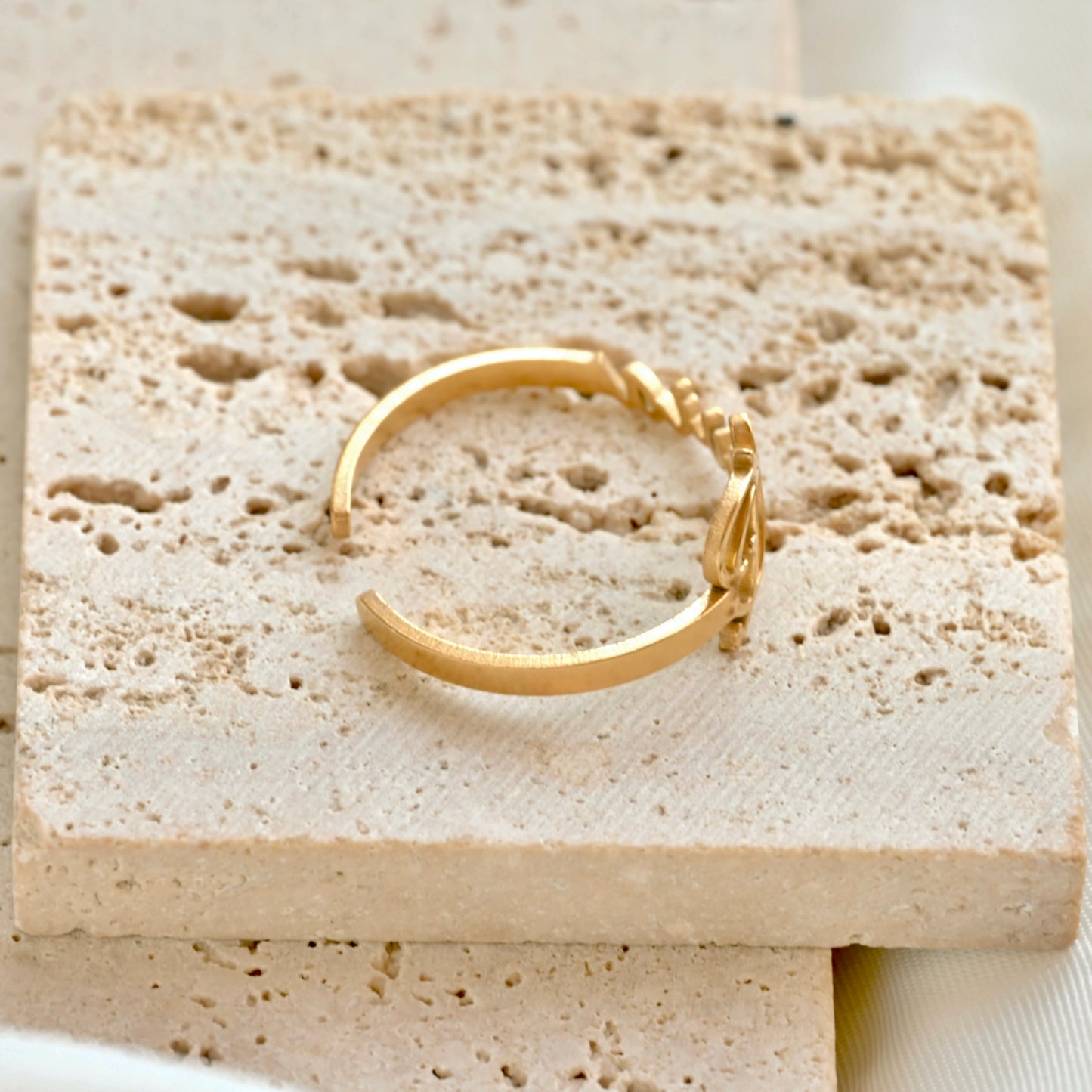 top voew of the name ring on a textured beige stone surface