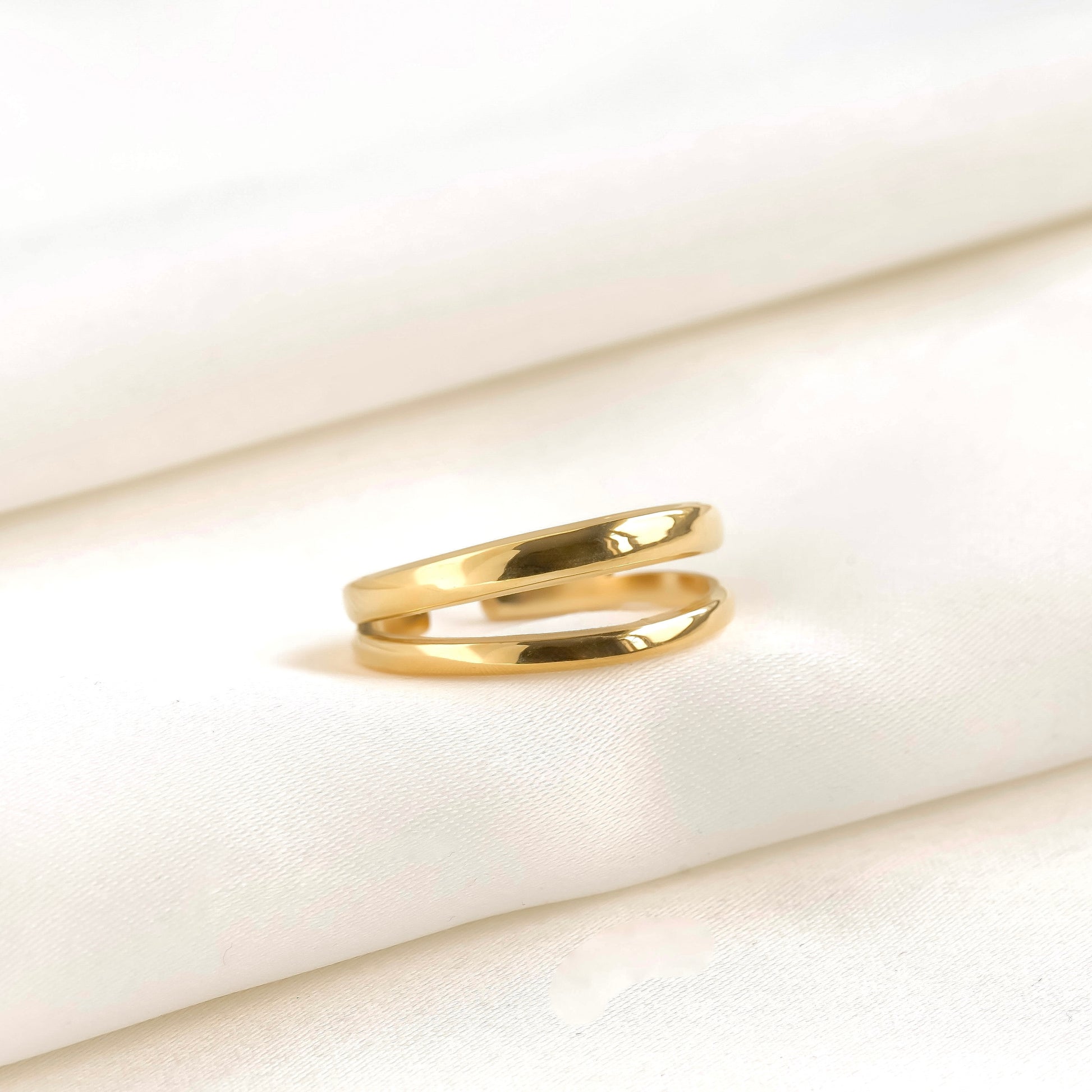 Double stacked bands ring on a soft beige fabric background