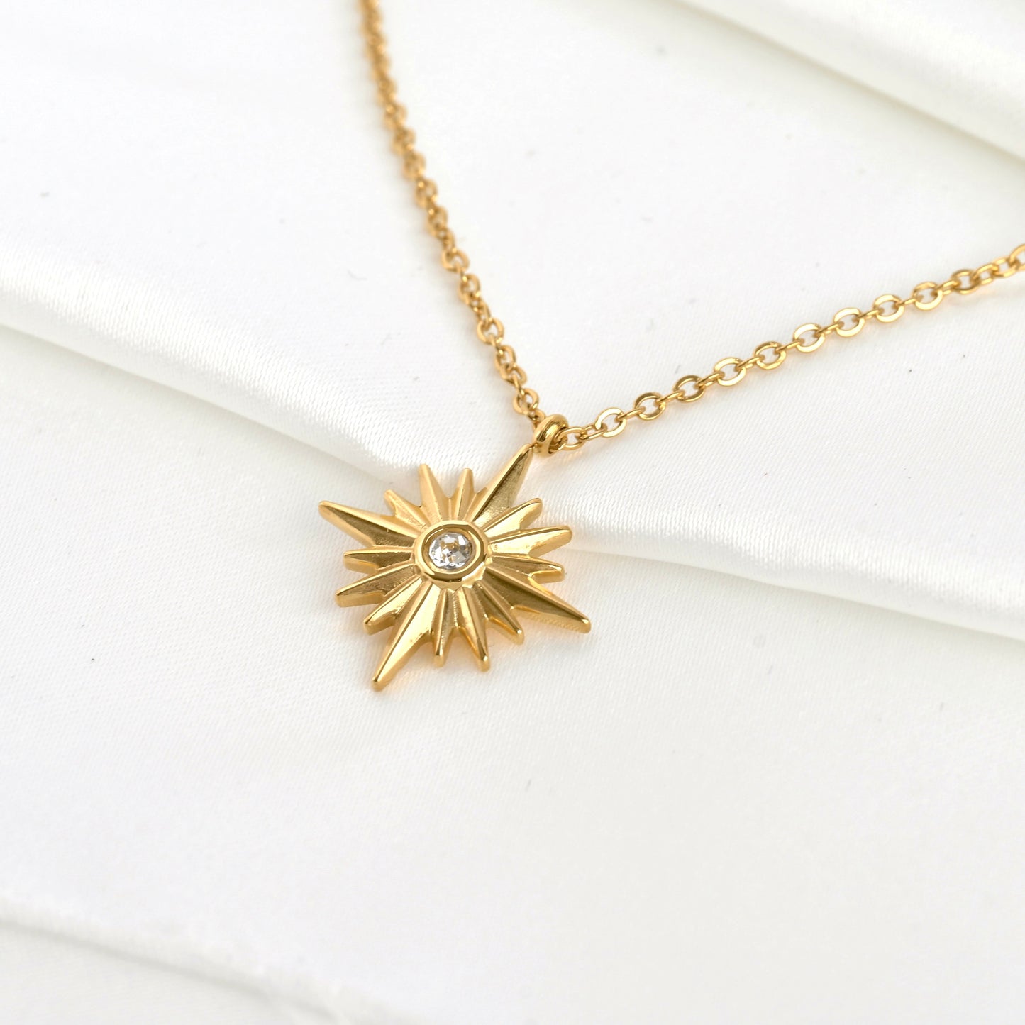 Top view of gold star pendant necklace on a white background