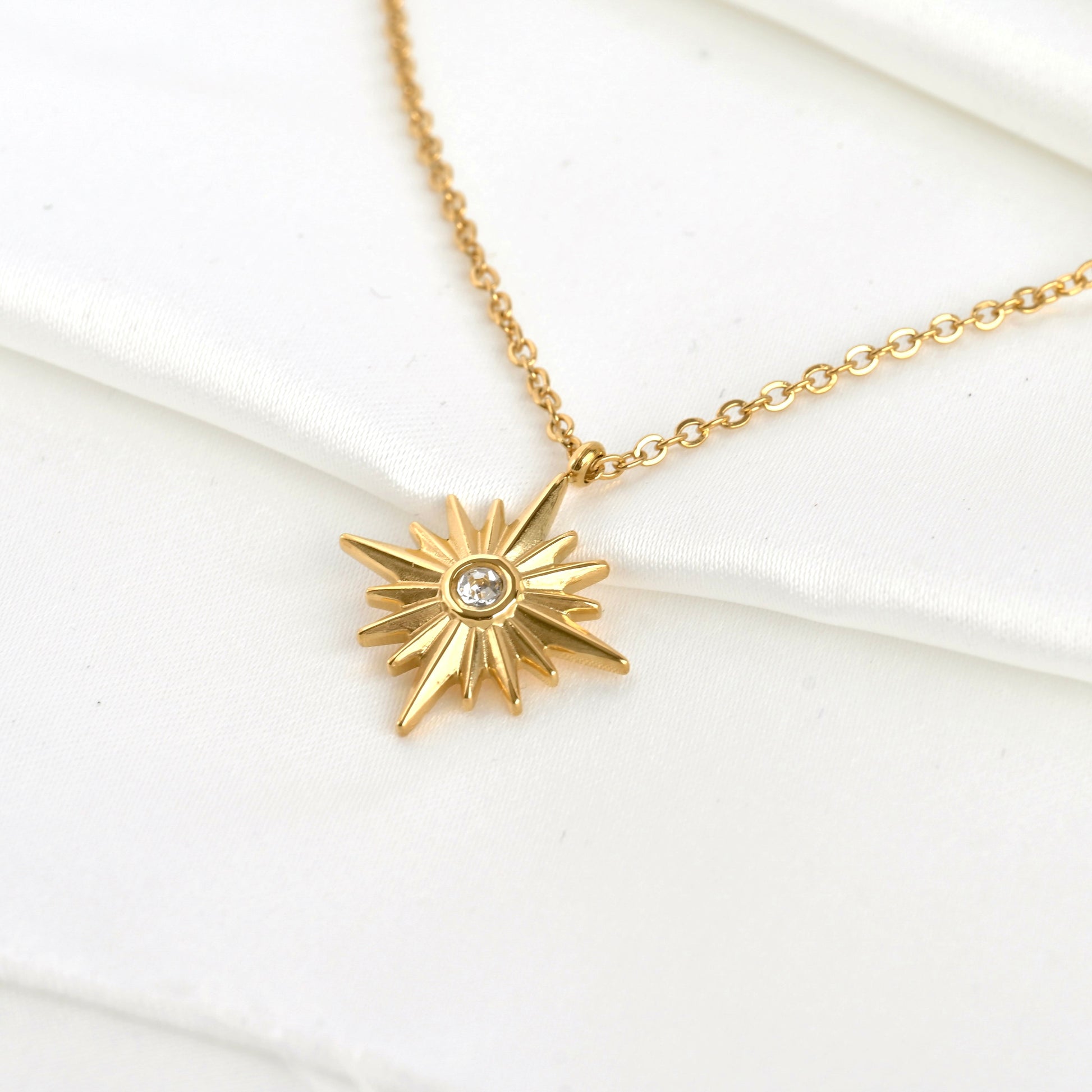 Top view of gold star pendant necklace on a white background
