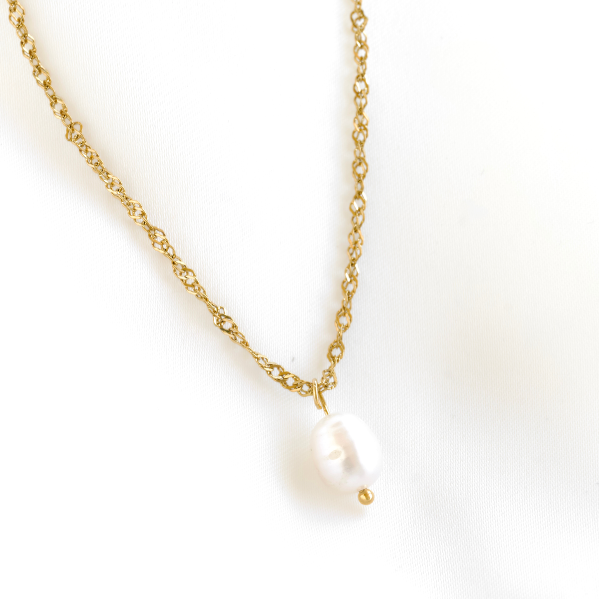 A delicate gold  twisted chain necklace featuring a single irregular white baroque pearl pendant, displayed on a clean white background.