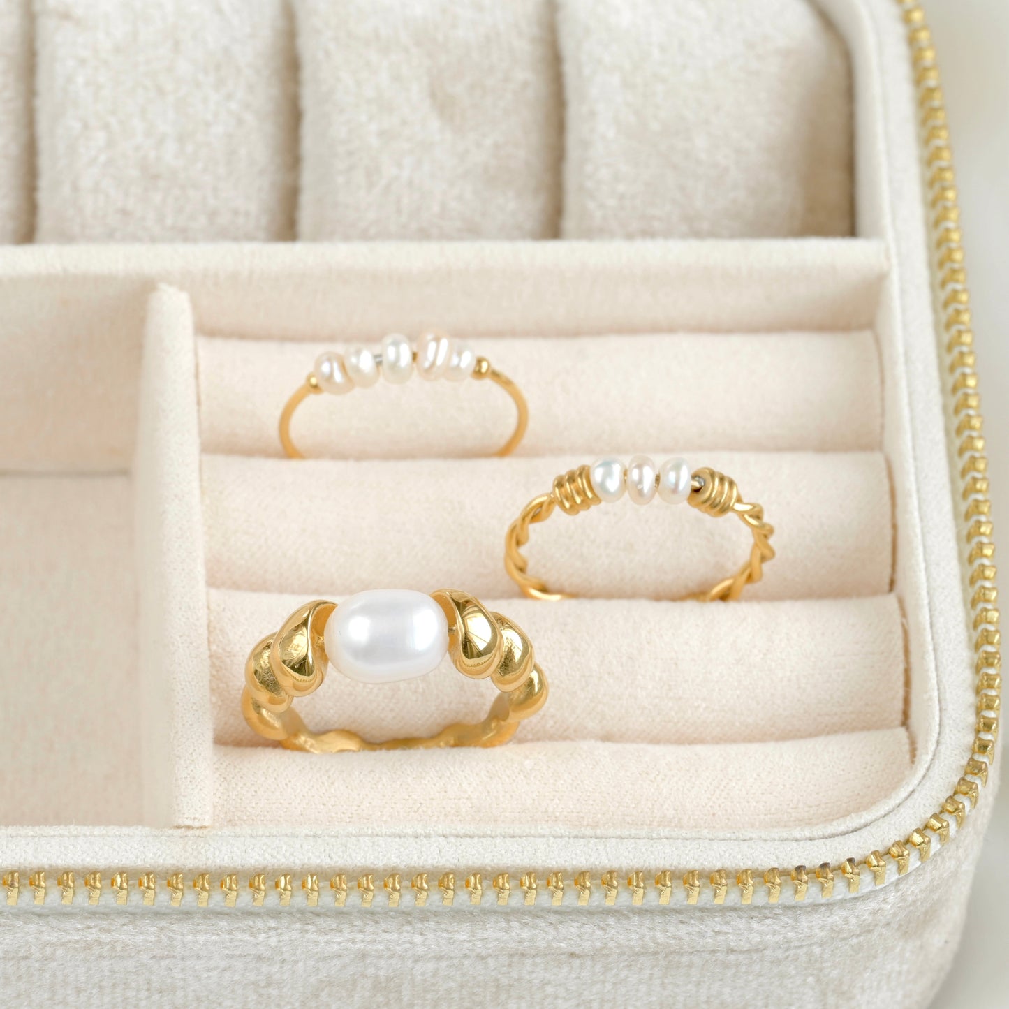 Three gold rings with pearls in a jewelry box