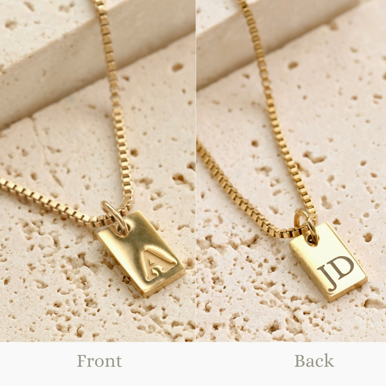 Gold necklace with a double sided engraved initial charm displaying initials on a textured beige surface.