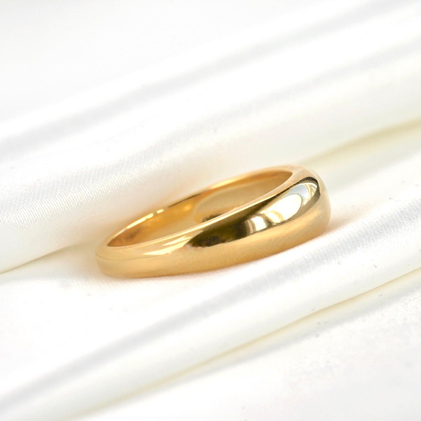 Gold ring on a white fabric background
