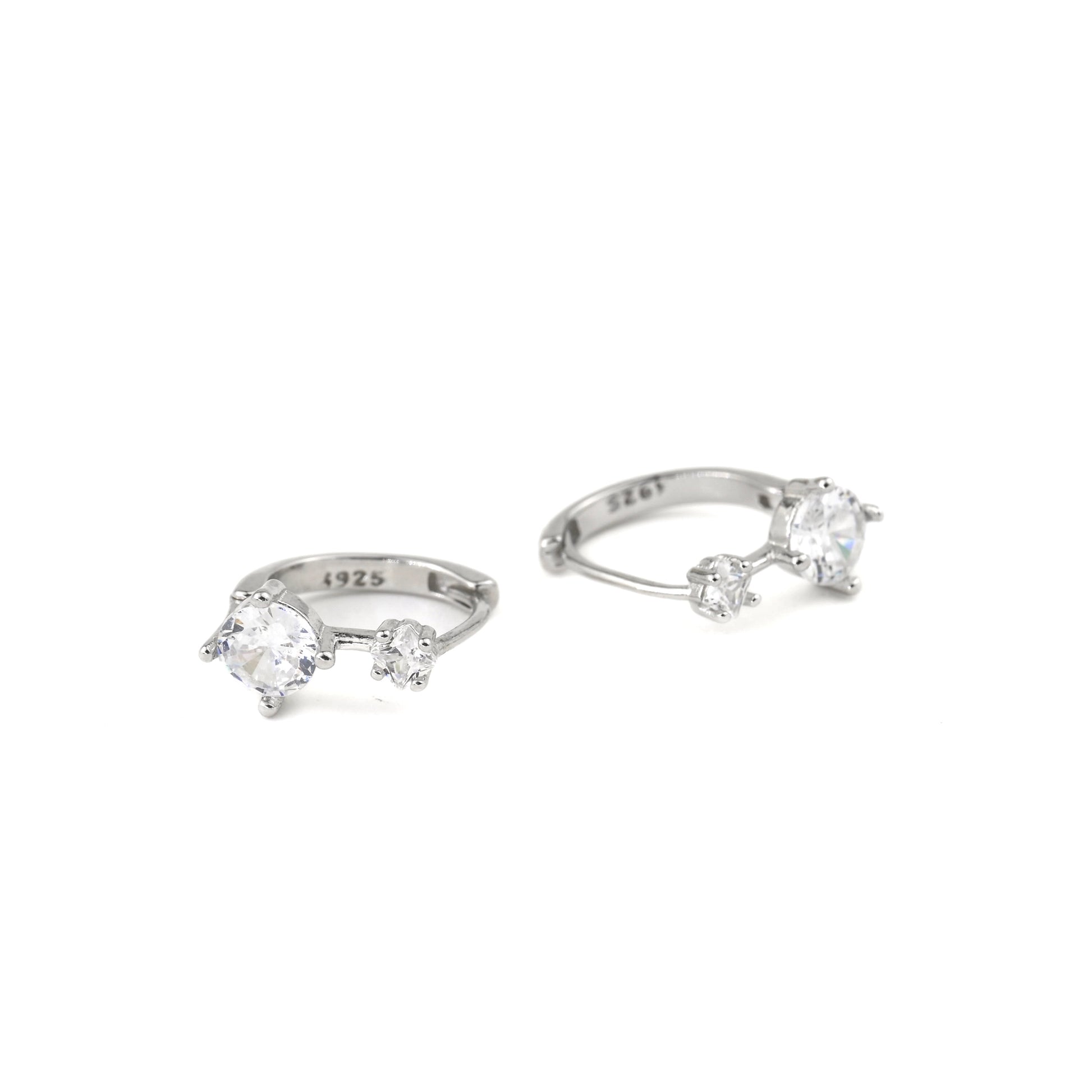 silver huggie earrings with one small and one medium sized CZ and S925 hallmark