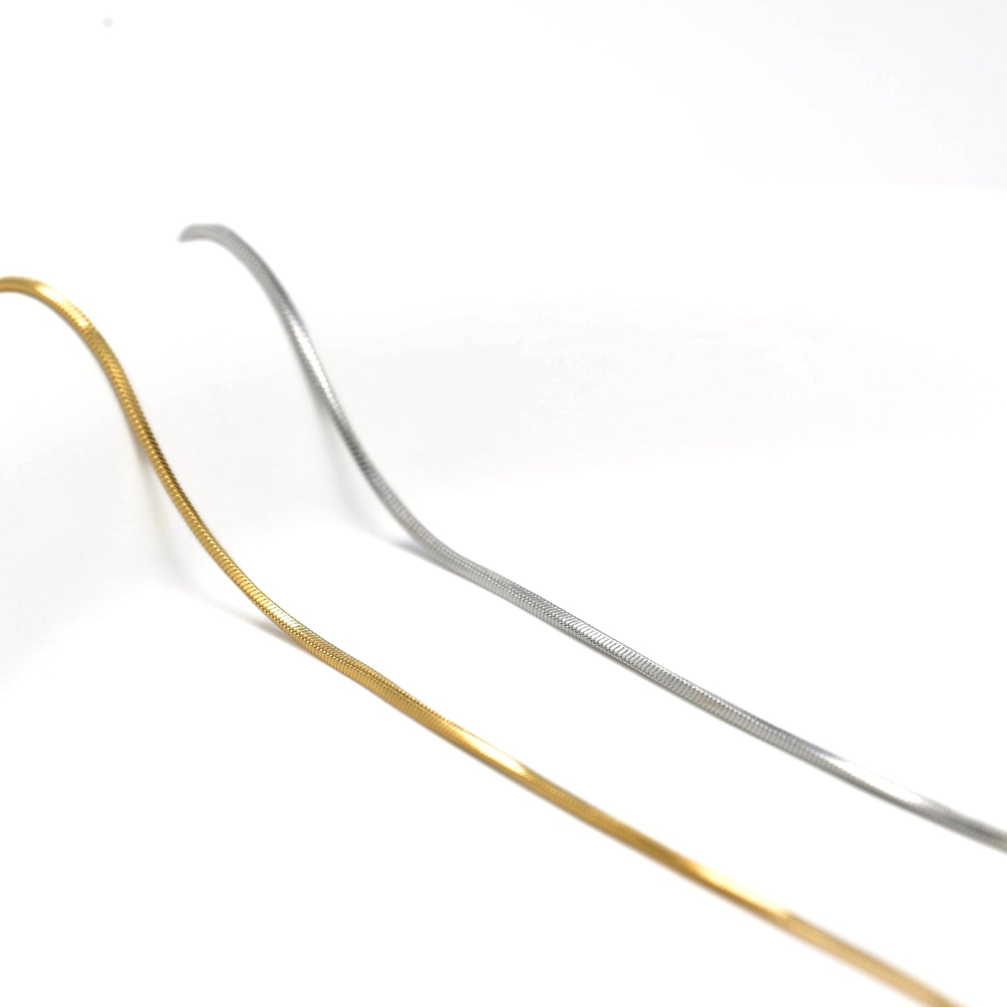 Two tone thin snake chain necklace, on a white background