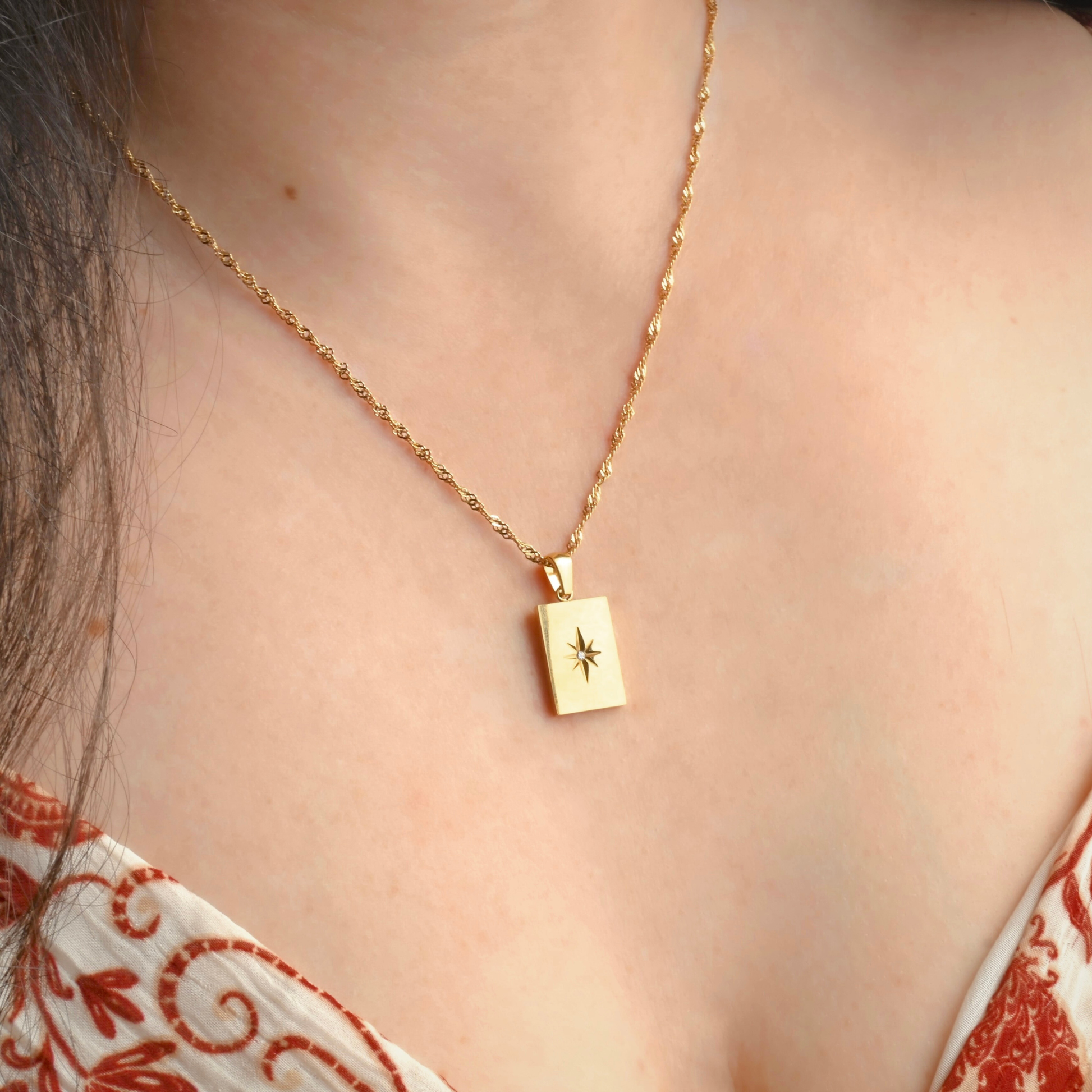Angled view of north star tag pendant on a person