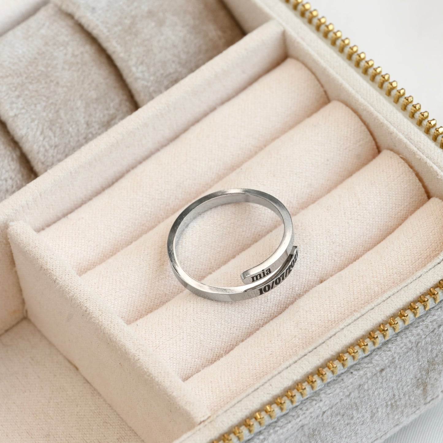 Silver ring with engraved text in a jewelry box