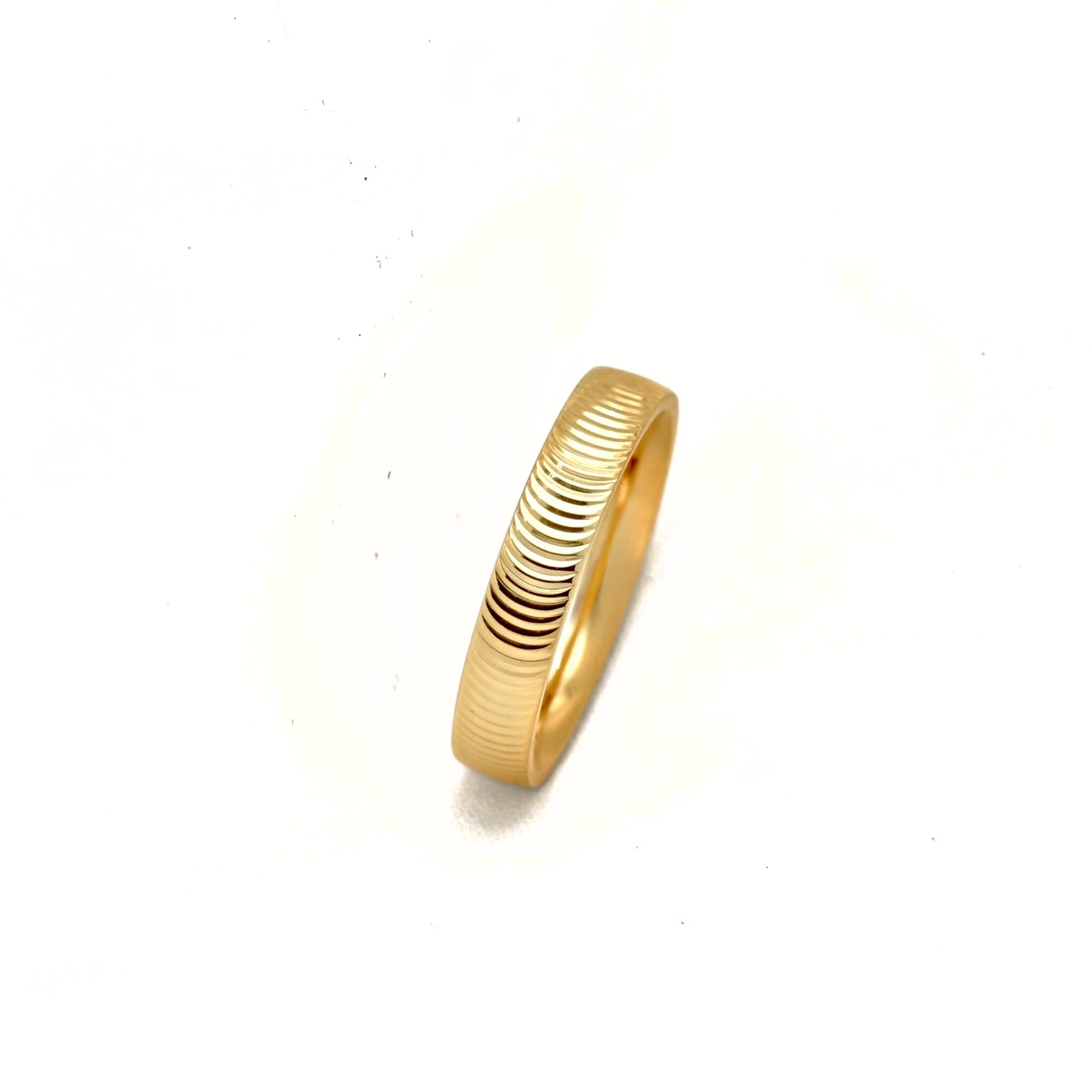 A gold ring with a textured, ribbed exterior and a smooth polished interior, shown on a plain white background.