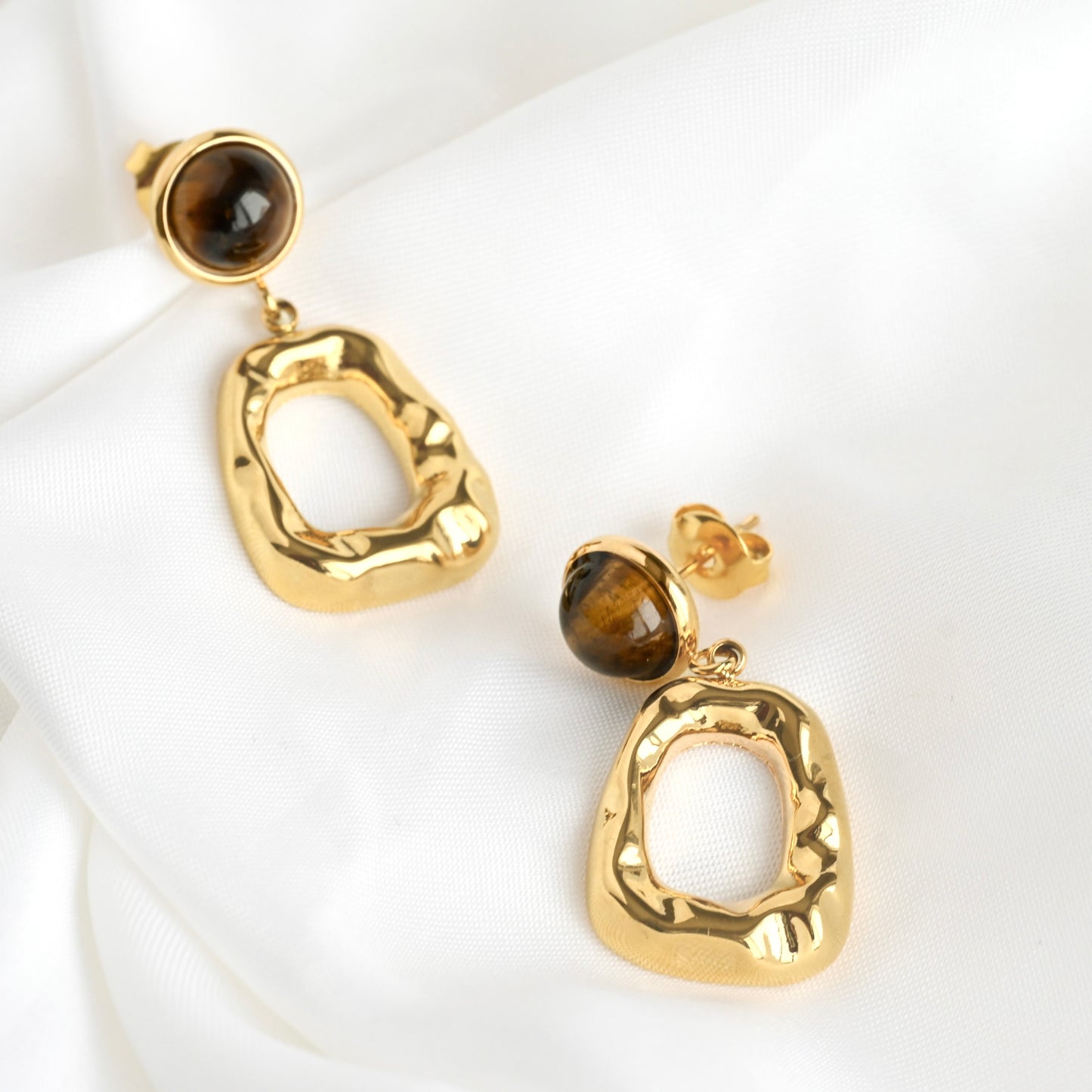 textured Gold dangle earrings with tigers eye stones on a white background