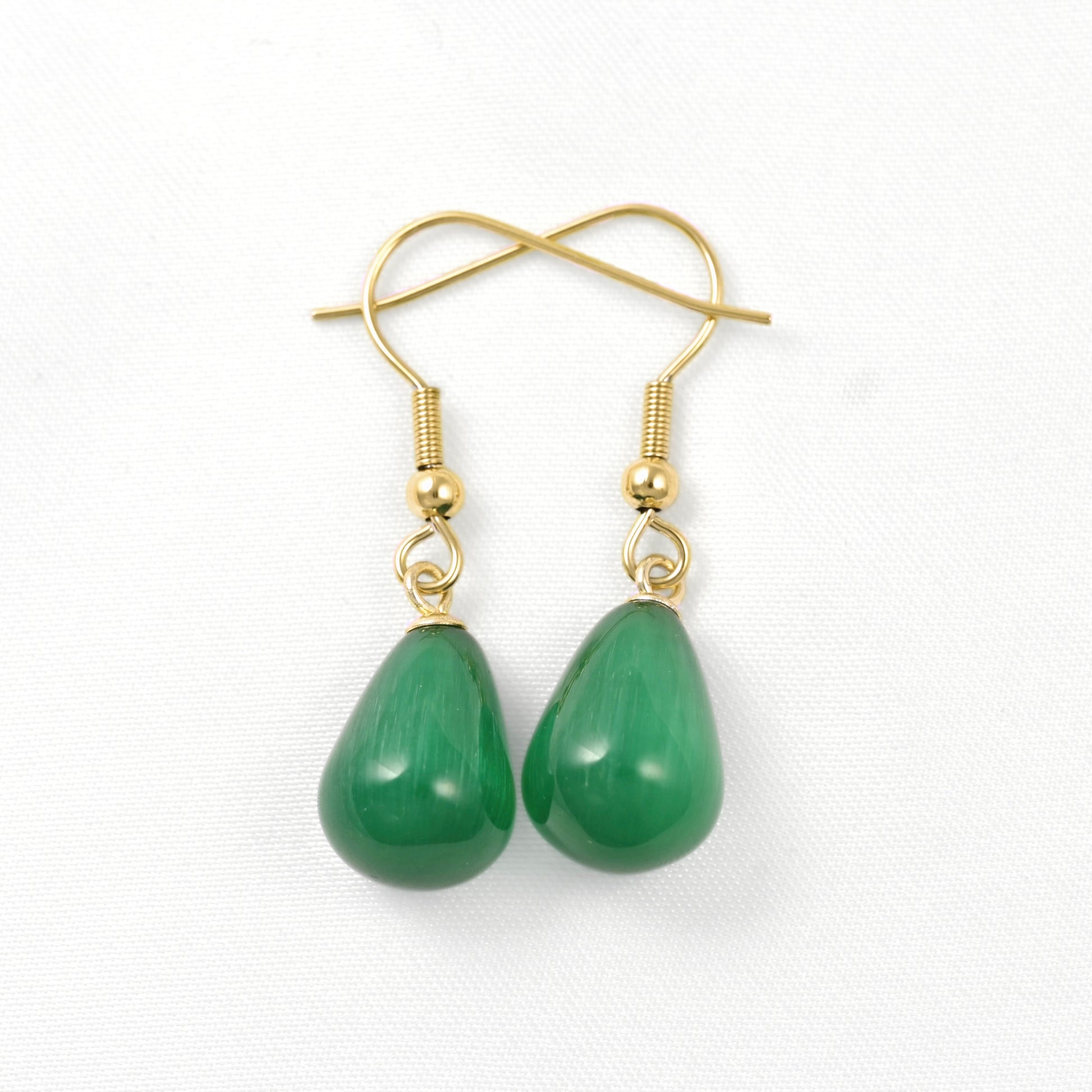A pair of gold-tone dangle earrings with teardrop-shaped green stone pendants, shown on a clean white background.