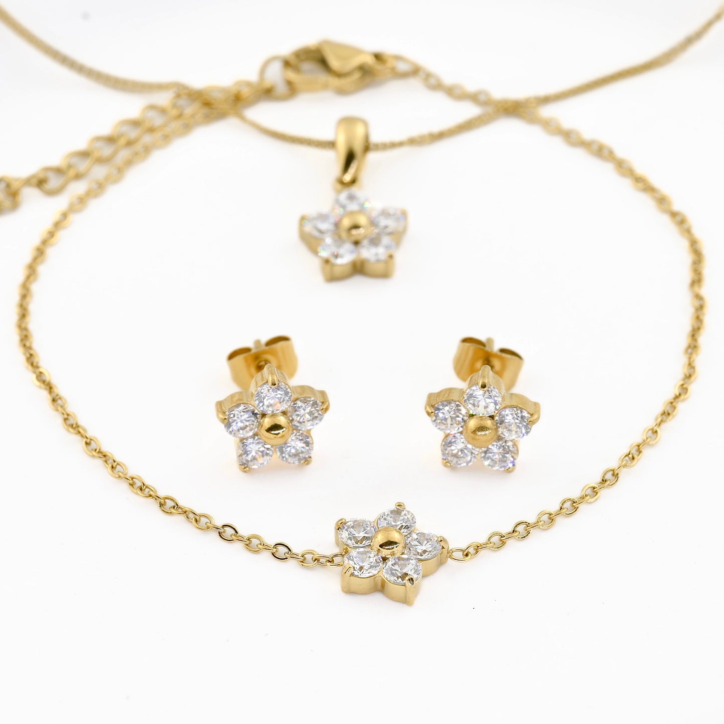 front view of the. Gold jewelry set with floral designs on a white background