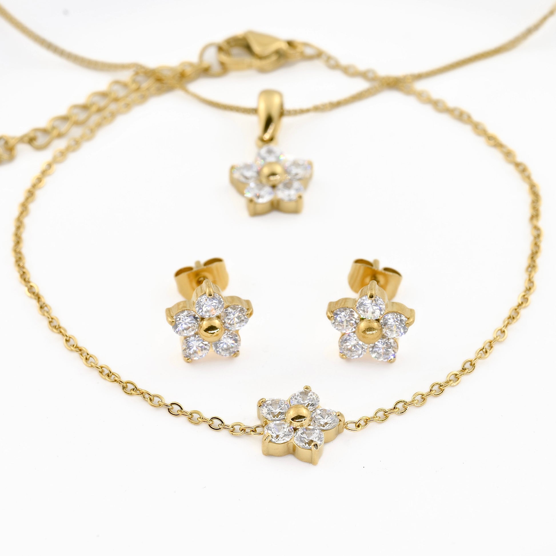 front view of the. Gold jewelry set with floral designs on a white background