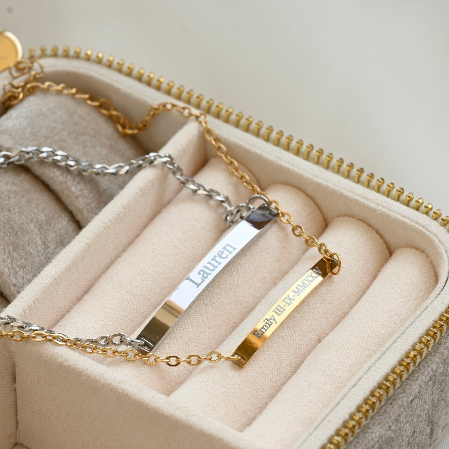 Gold and silver bracelets with nameplates in a jewelry box