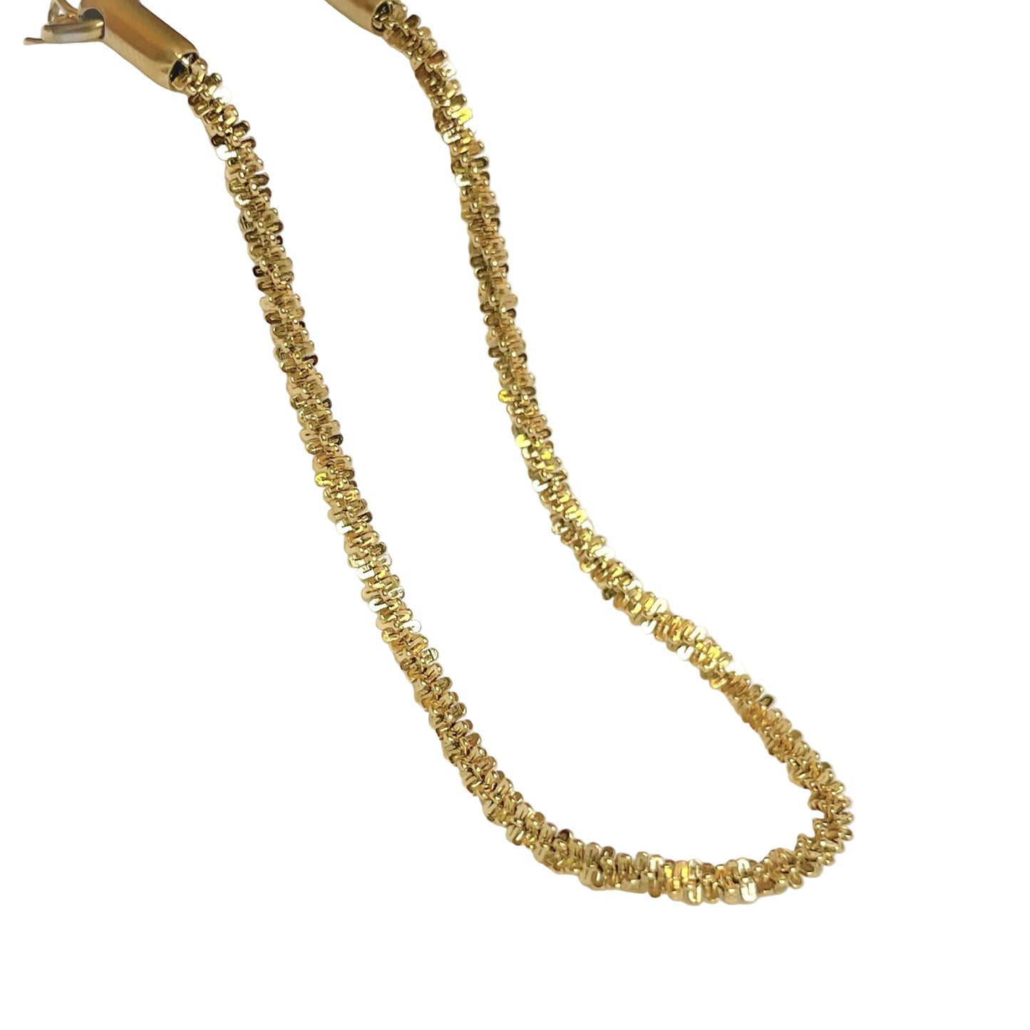 Shimmering gold chain bracelet on a white fabric background