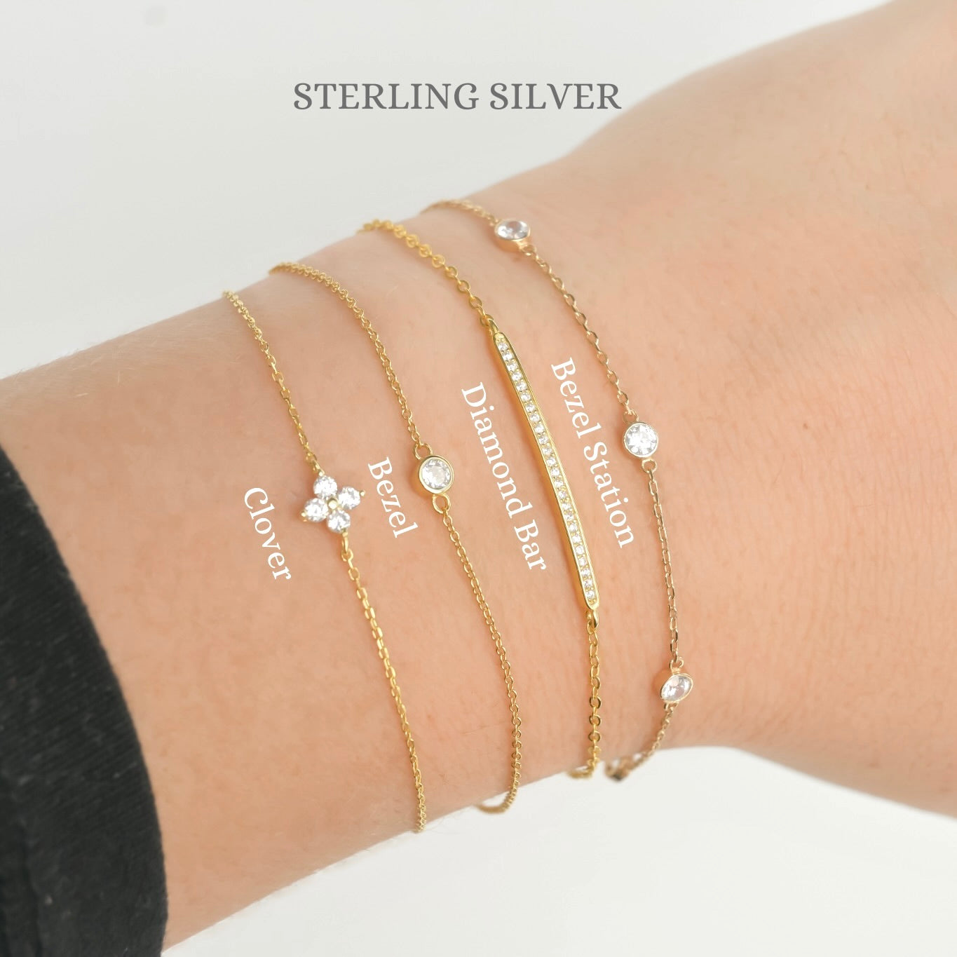 Gold bracelets with various designs on a wrist, labeled 'Sterling Silver'.