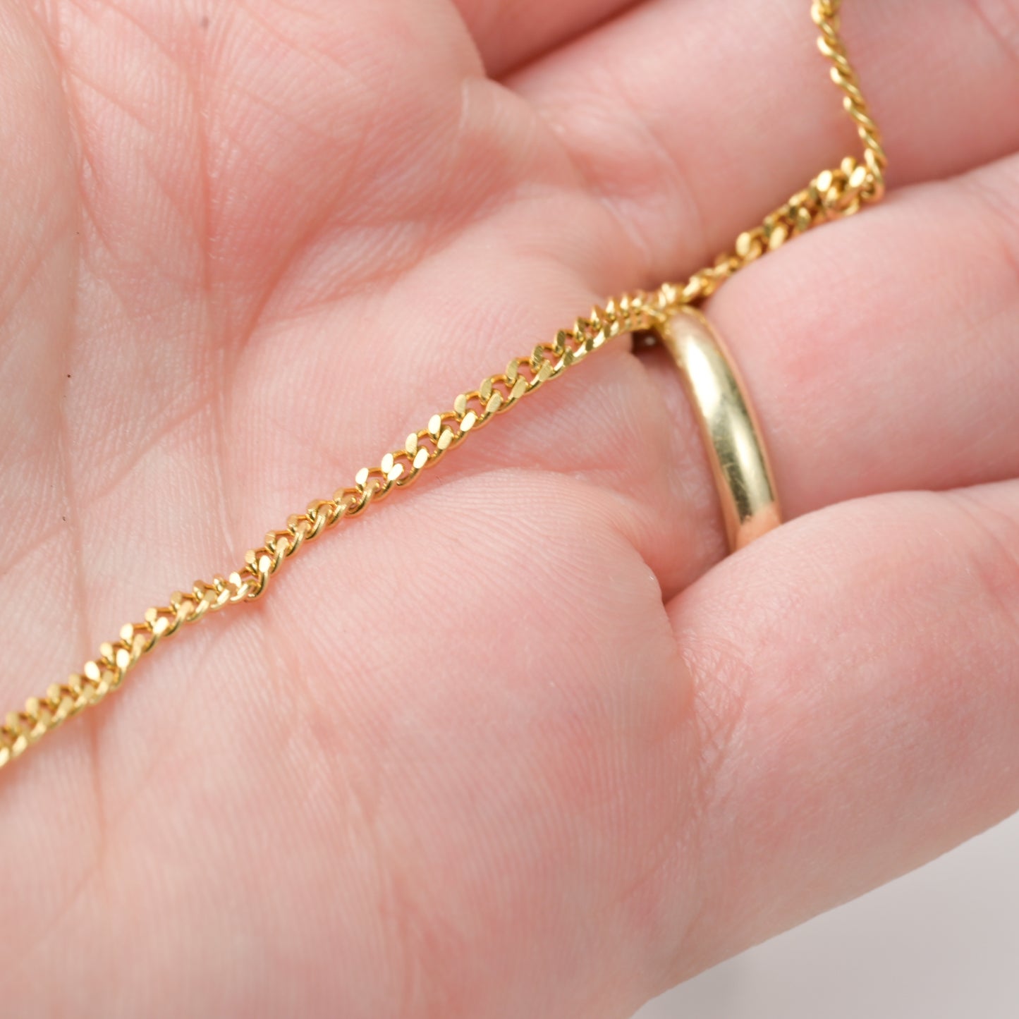 2mm cuban chain anklet held in a hand