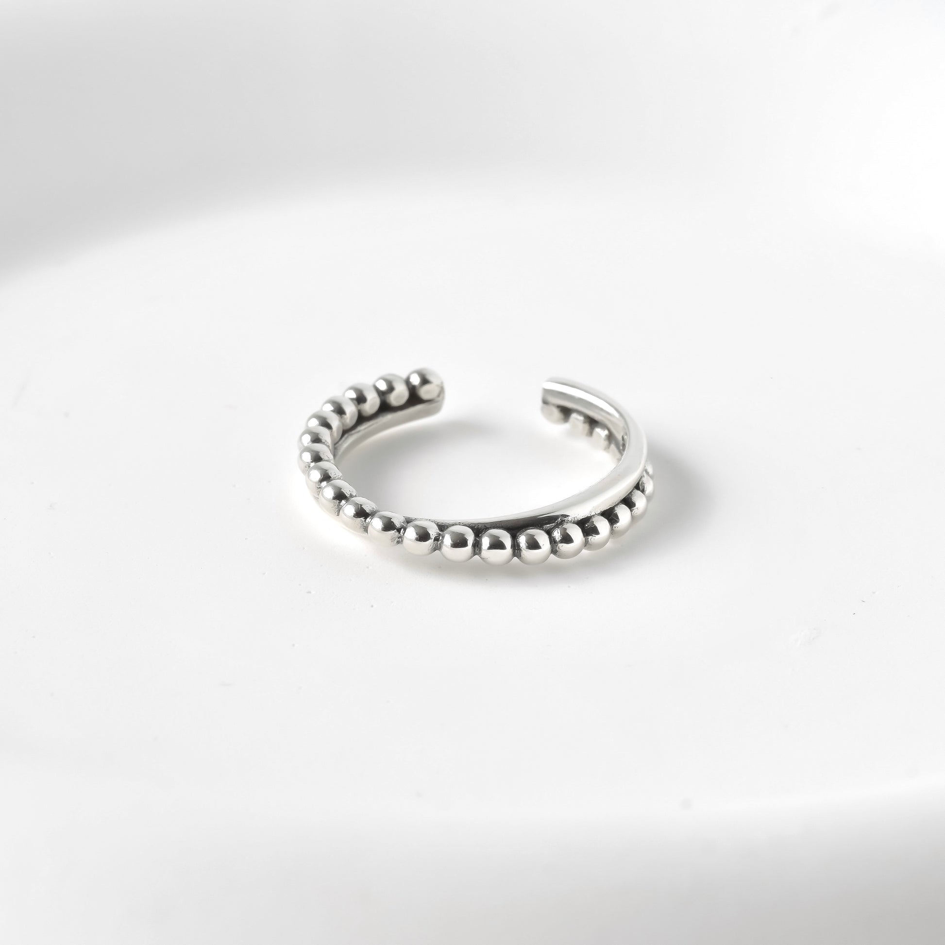 Adjustable silver beaded ring on a white background