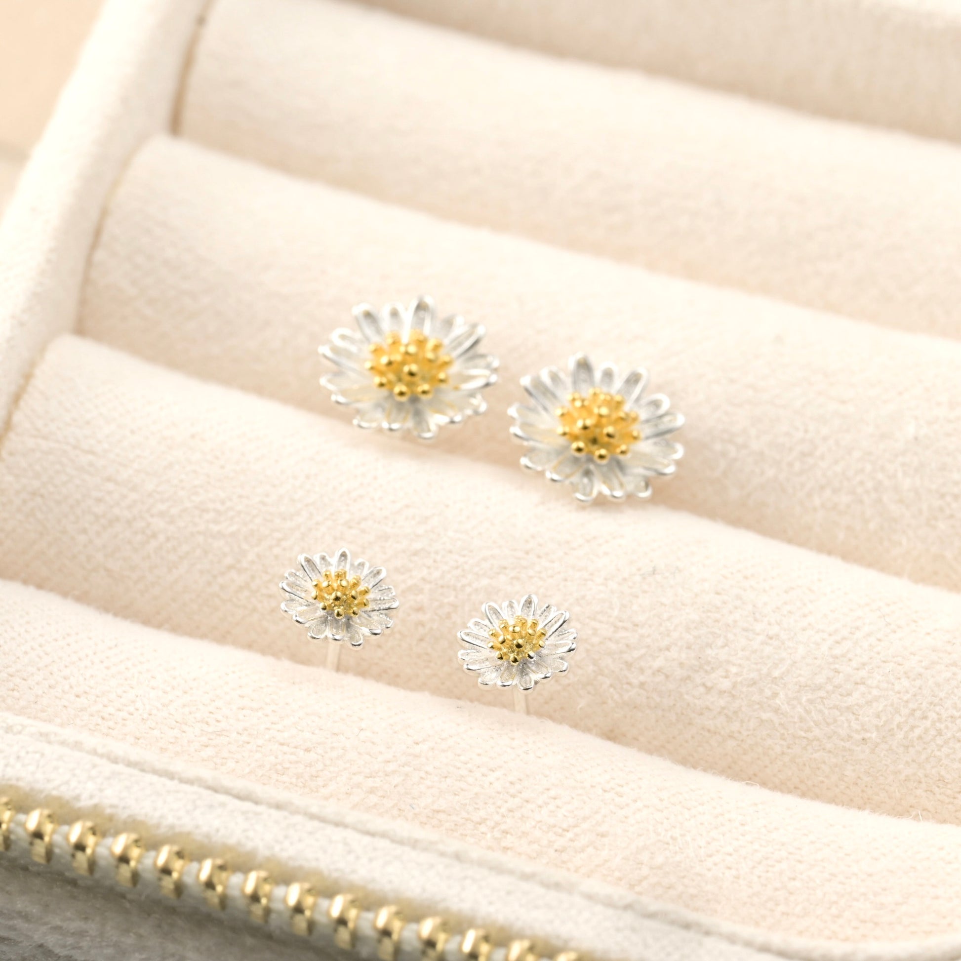 angled view of earrings in a beige fabric  jewelry display