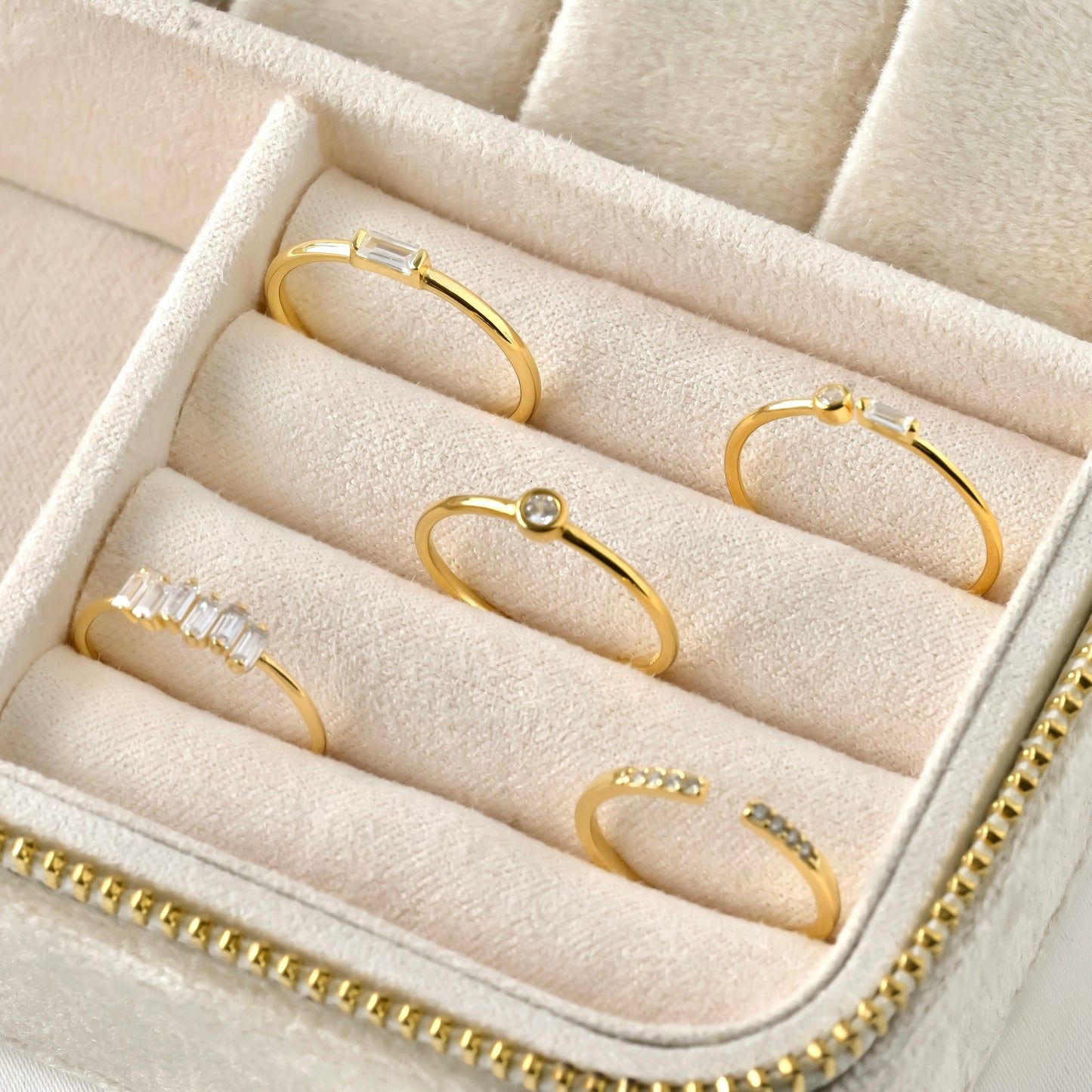 Set of gold rings with diamonds with different settings in a jewelry box