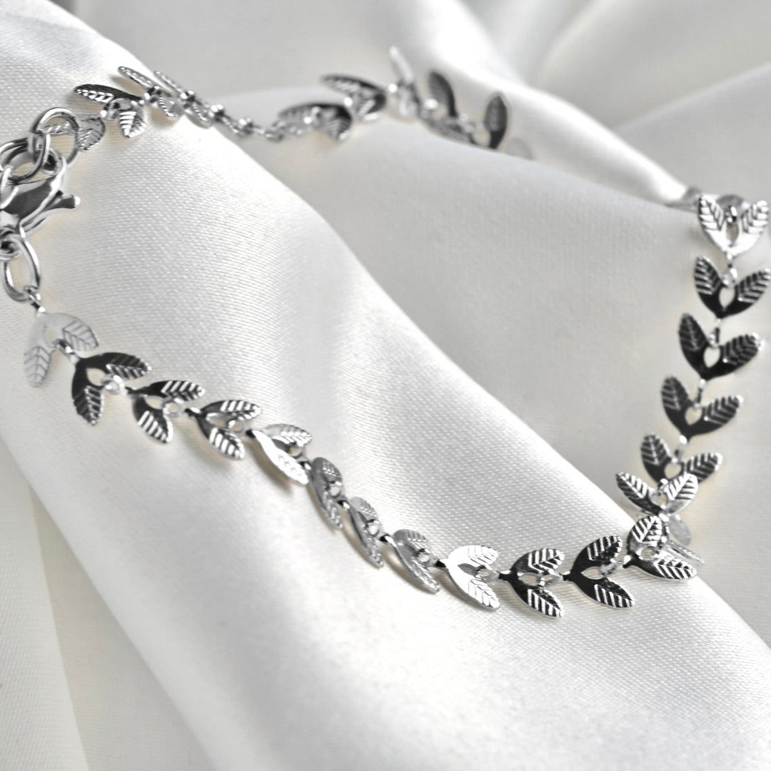 Silver leaf bracelet on a white fabric background
