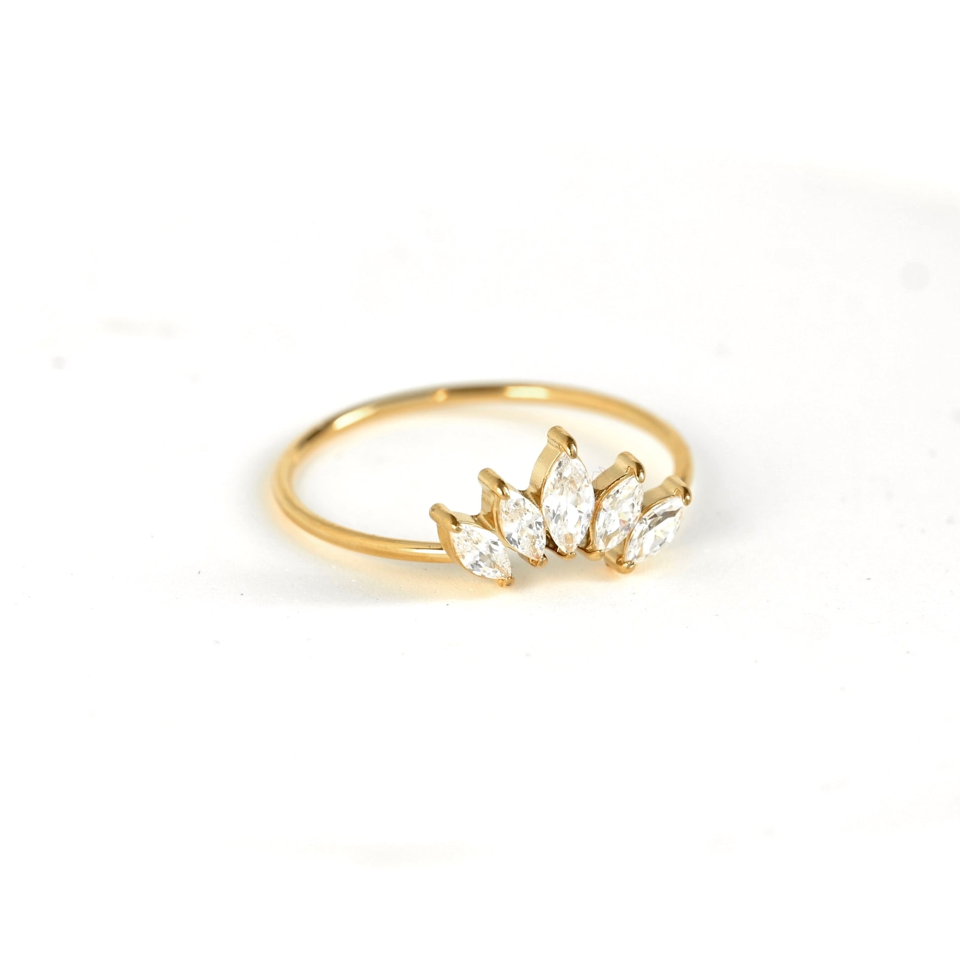 A gold ring featuring a cluster of marquise-cut clear gemstones, photographed on a clean white background.