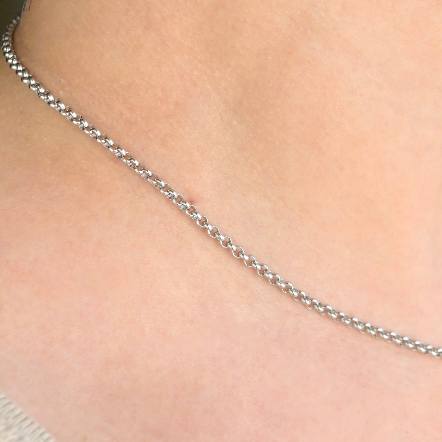 close up view of silver chain necklace on a person's neck