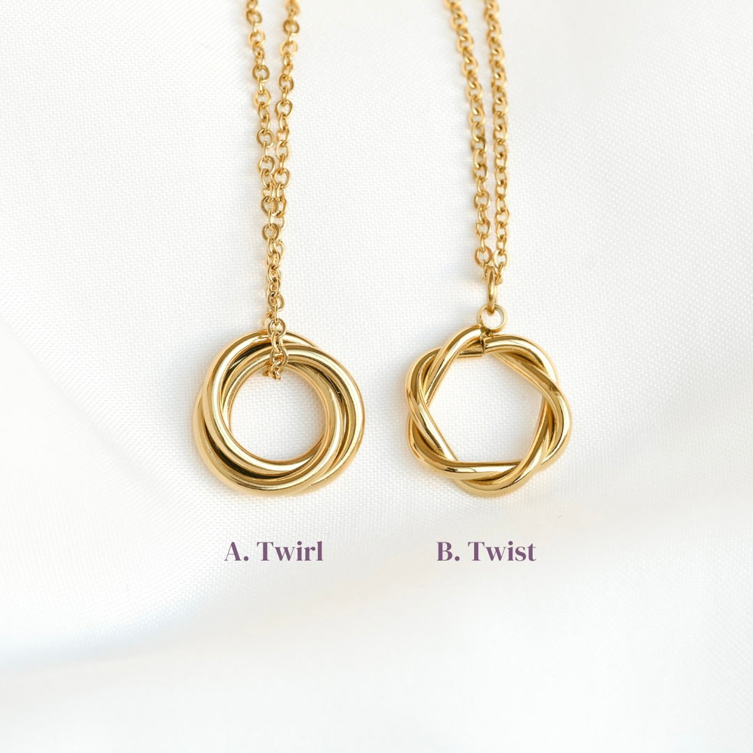 Two gold necklaces labeled 'Twirl' and 'Twist' on a white background