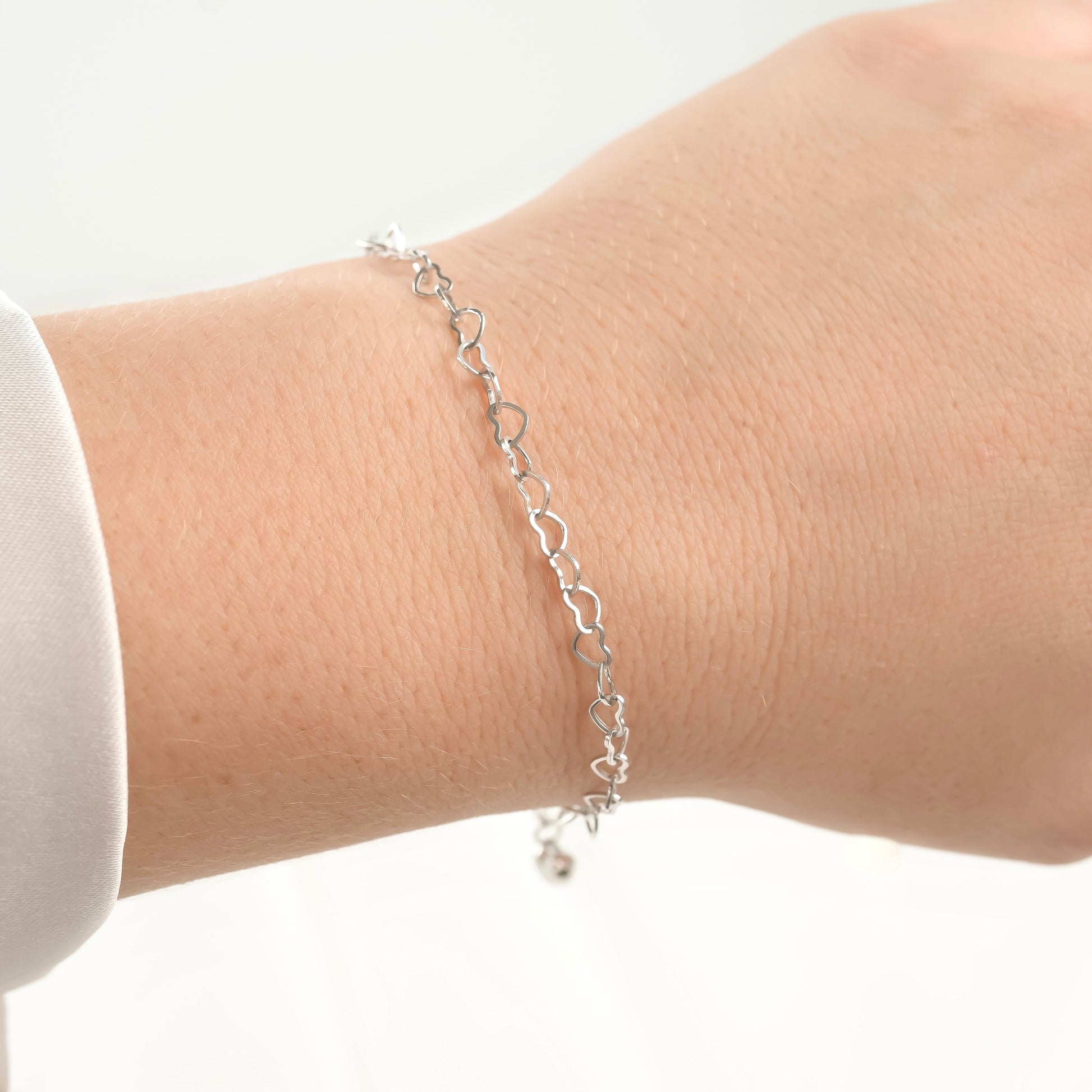 angled view of silver heart chain under direct sunlight