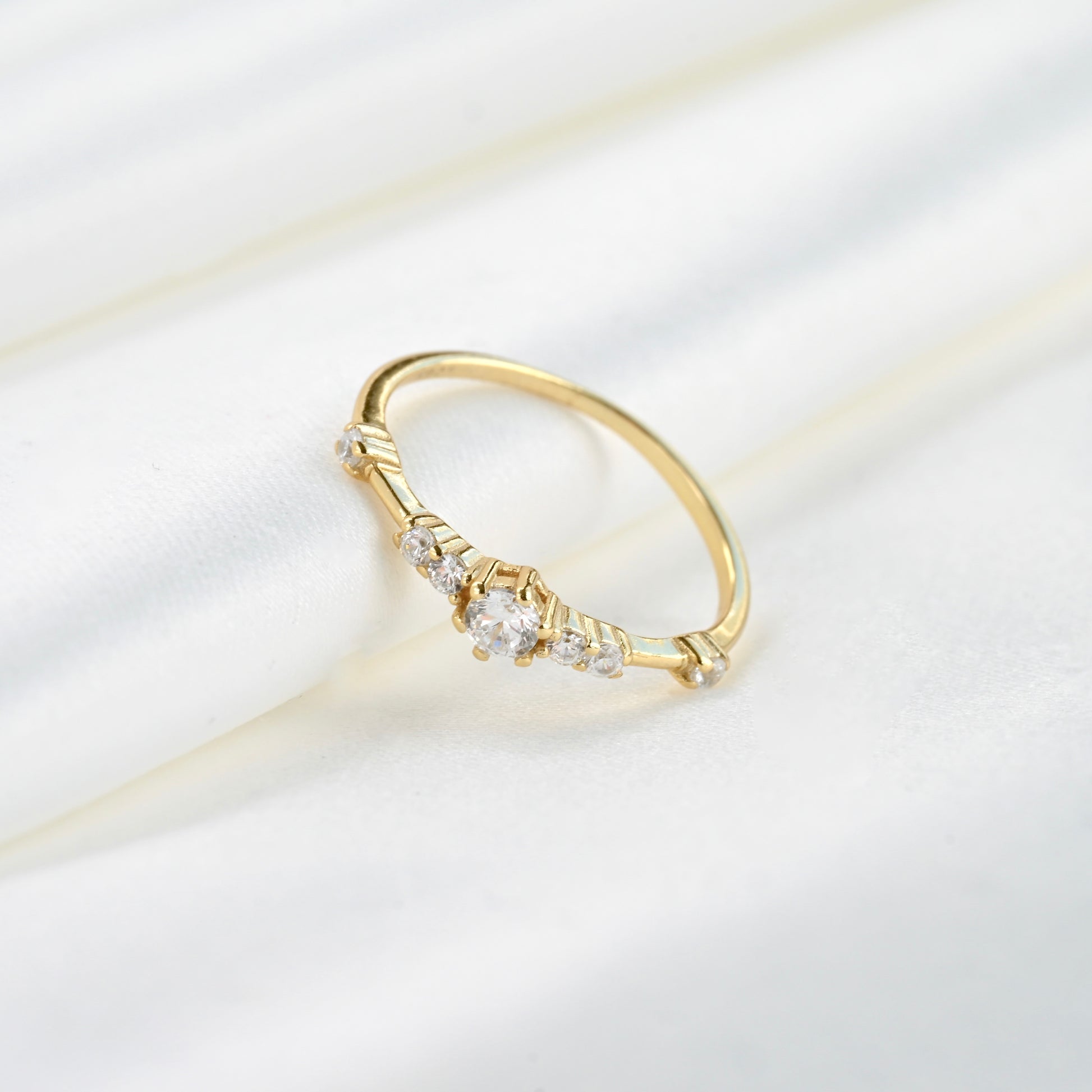 Gold ring with small diamonds on a light background