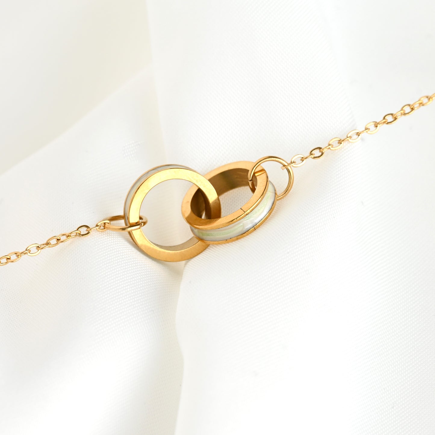 Shell inlay karma bracelet with two interlocked circles on a white background
