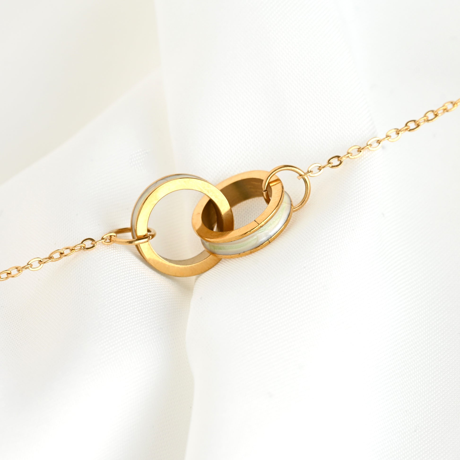 Shell inlay karma bracelet with two interlocked circles on a white background

