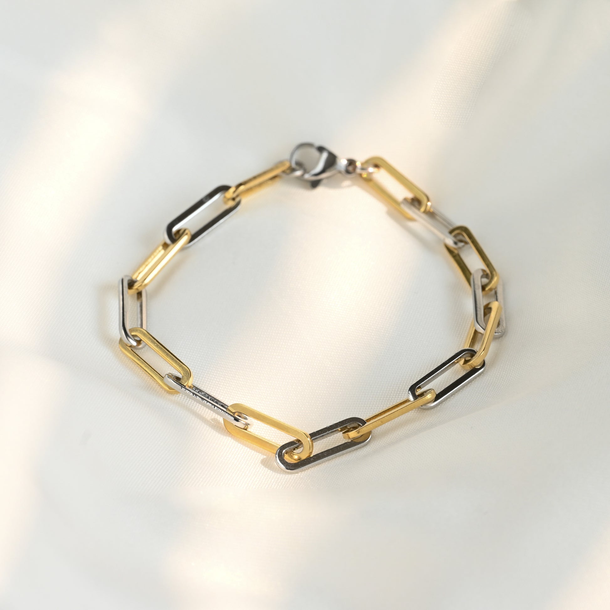 Two-tone thick chain bracelet on a light gray background