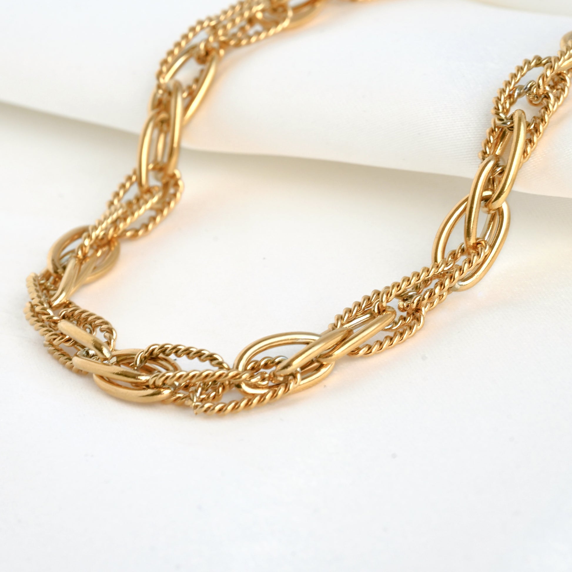 Textured gold chain necklace on a white background