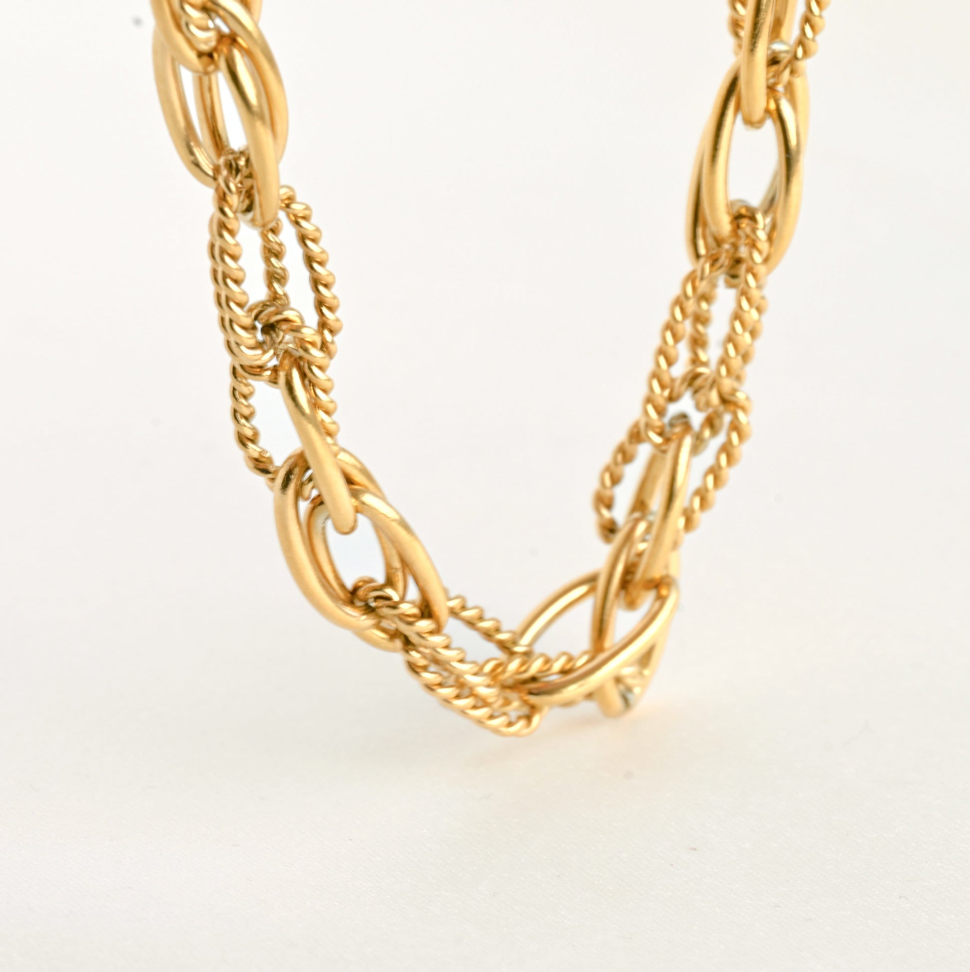 Gold chain necklace on a light beige background