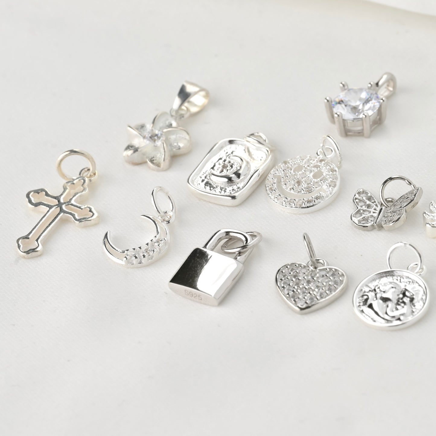 Collection of various silver pendants on a light background