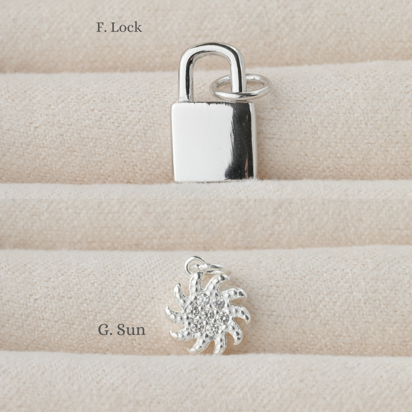 Silver padlock and sun-shaped charm on a textured beige surface