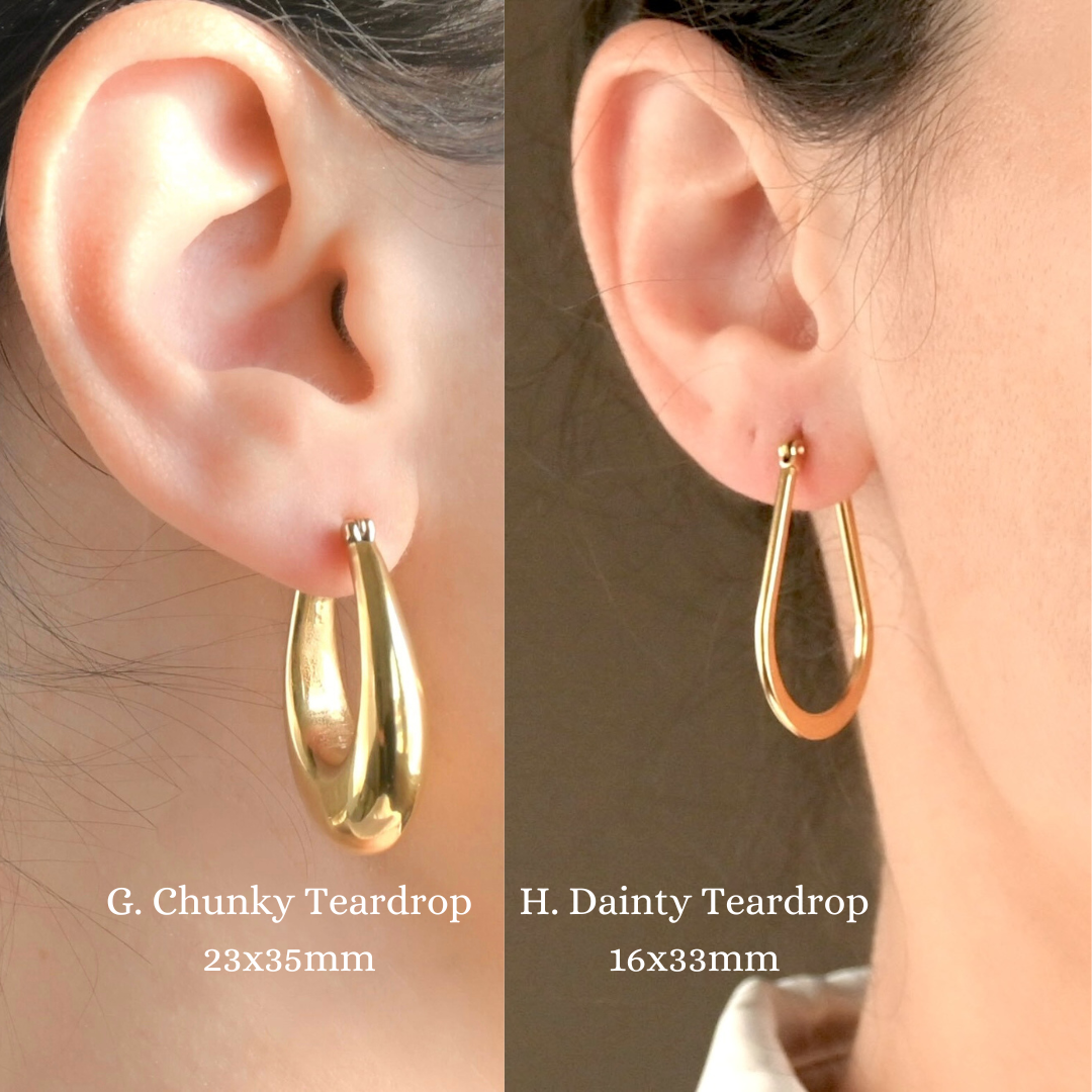 Two gold  teardrop hoop earrings, one slim with a teardrop outline shape, one ultra chunky on ears with text labels.