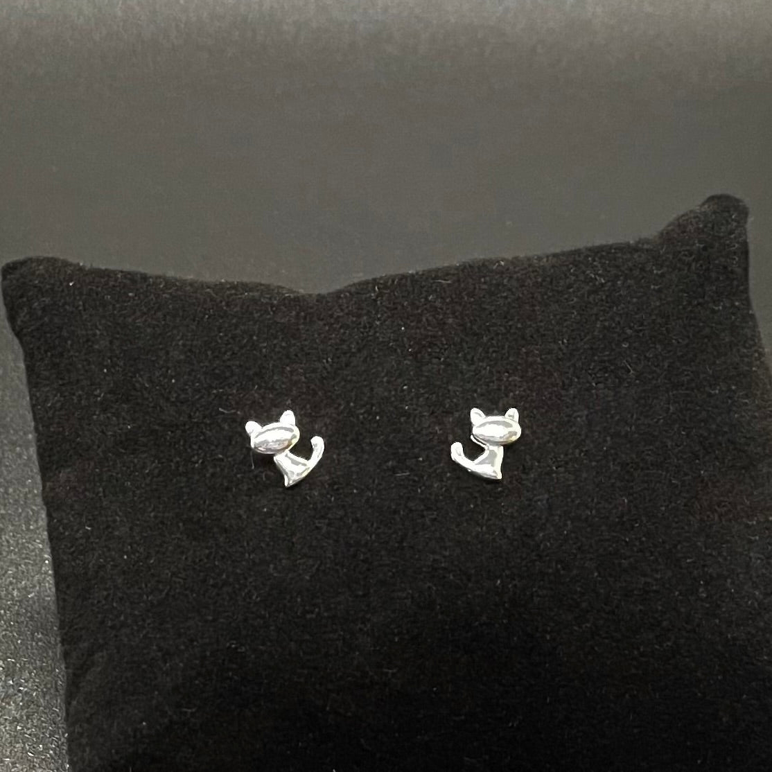 Silver cat stud earrings on a black cushion