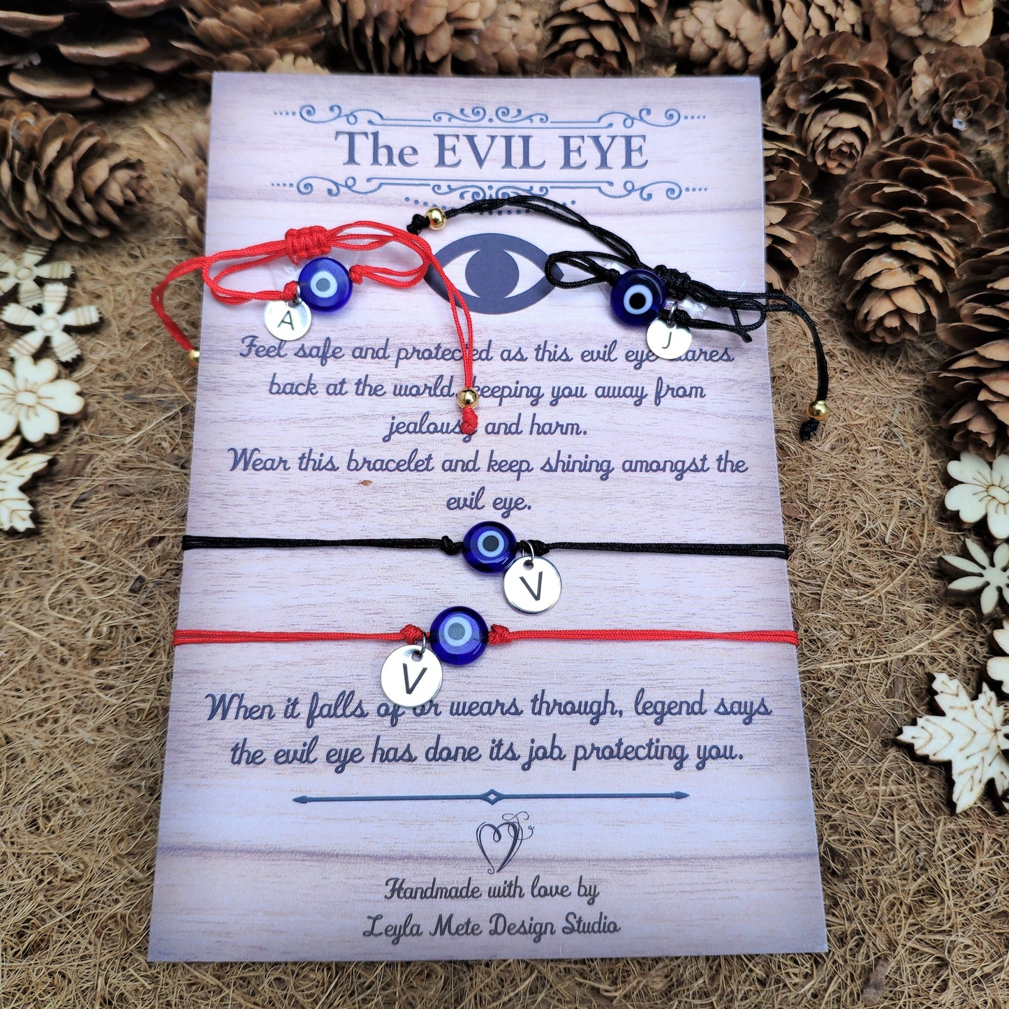 Two evil eye bracelets on a card with decorative elements on a textured surface