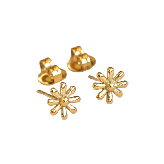 Gold daisy earrings and butterfly backings on a white background