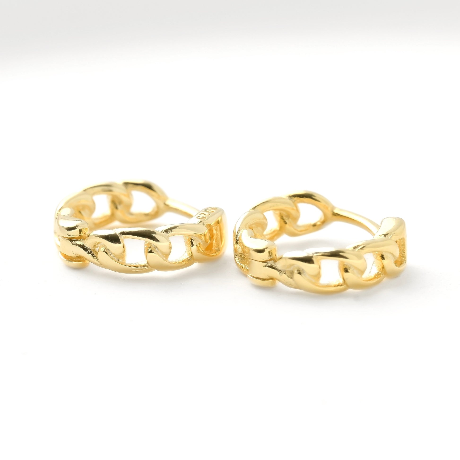 Pair of gold chain-link hoop earrings on a white background