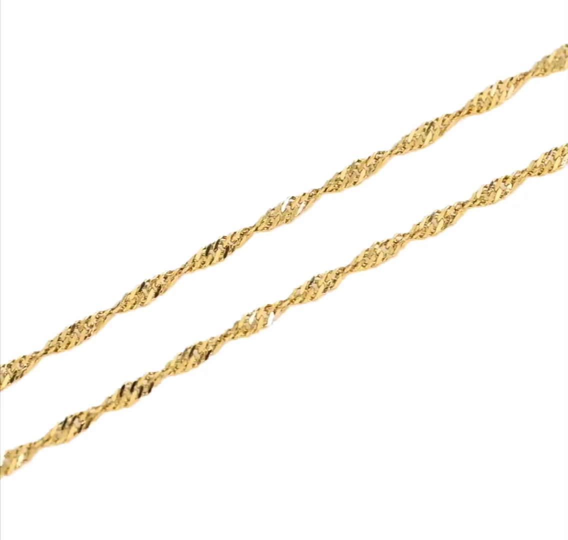two gold twist chains shimmering as they catch light