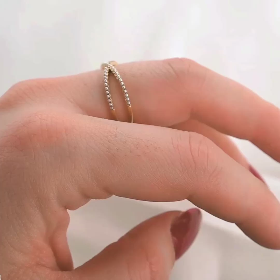 The view of dainty criss cross beaded ring from different angles on a person's finger as the hand moves