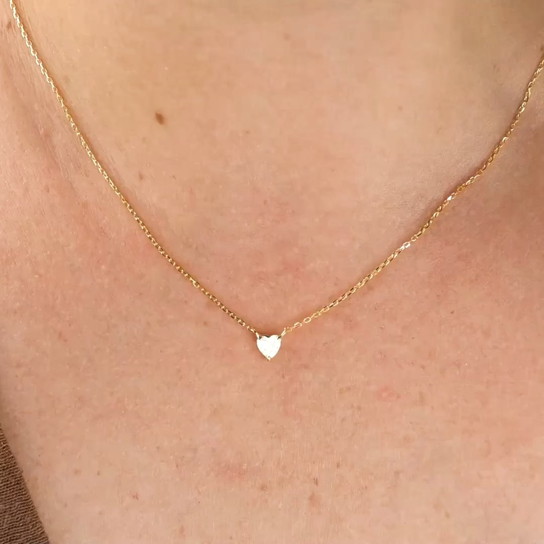 Sterling silver gold heart necklace with the chain shimmering as model turns